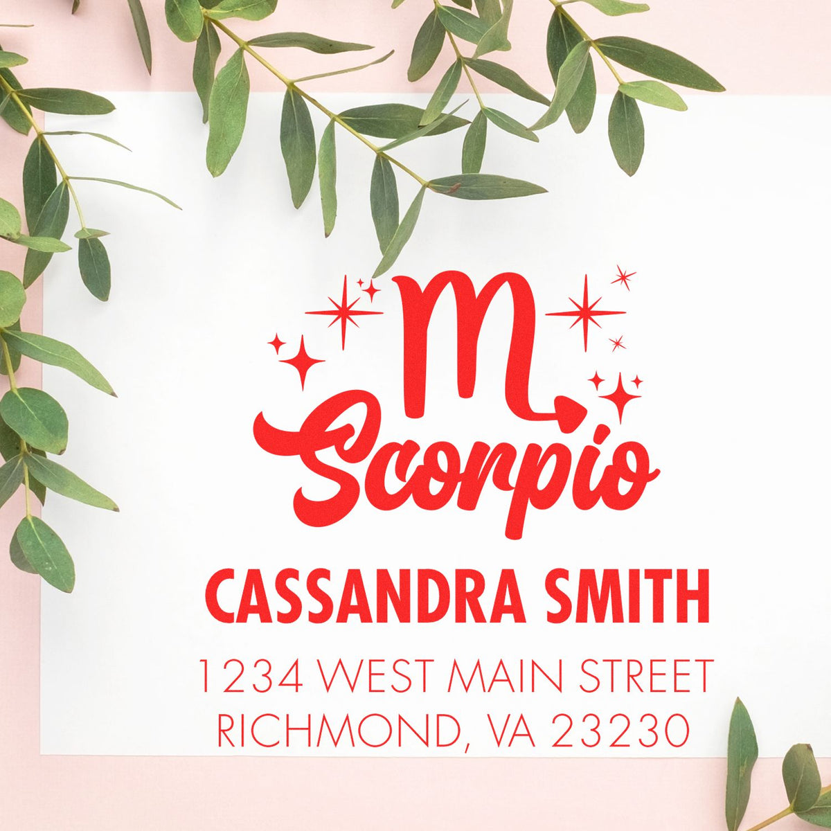 Custom red Scorpio stamp and seal with star accents, name Cassandra Smith and address on white, framed by green leaves.