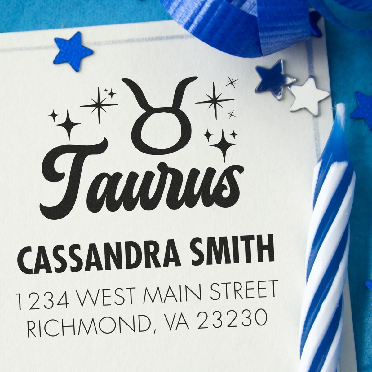 Black Taurus return address stamp on white paper, with blue wax seals, star accents, and ribbon trim.