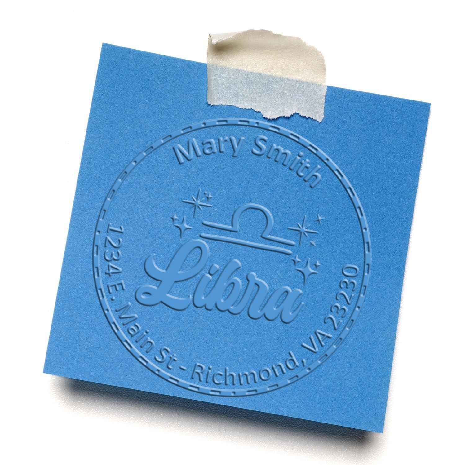 Blue embossed seal stamp on square card with tape, featuring Mary Smith and Libra inside a circular design.