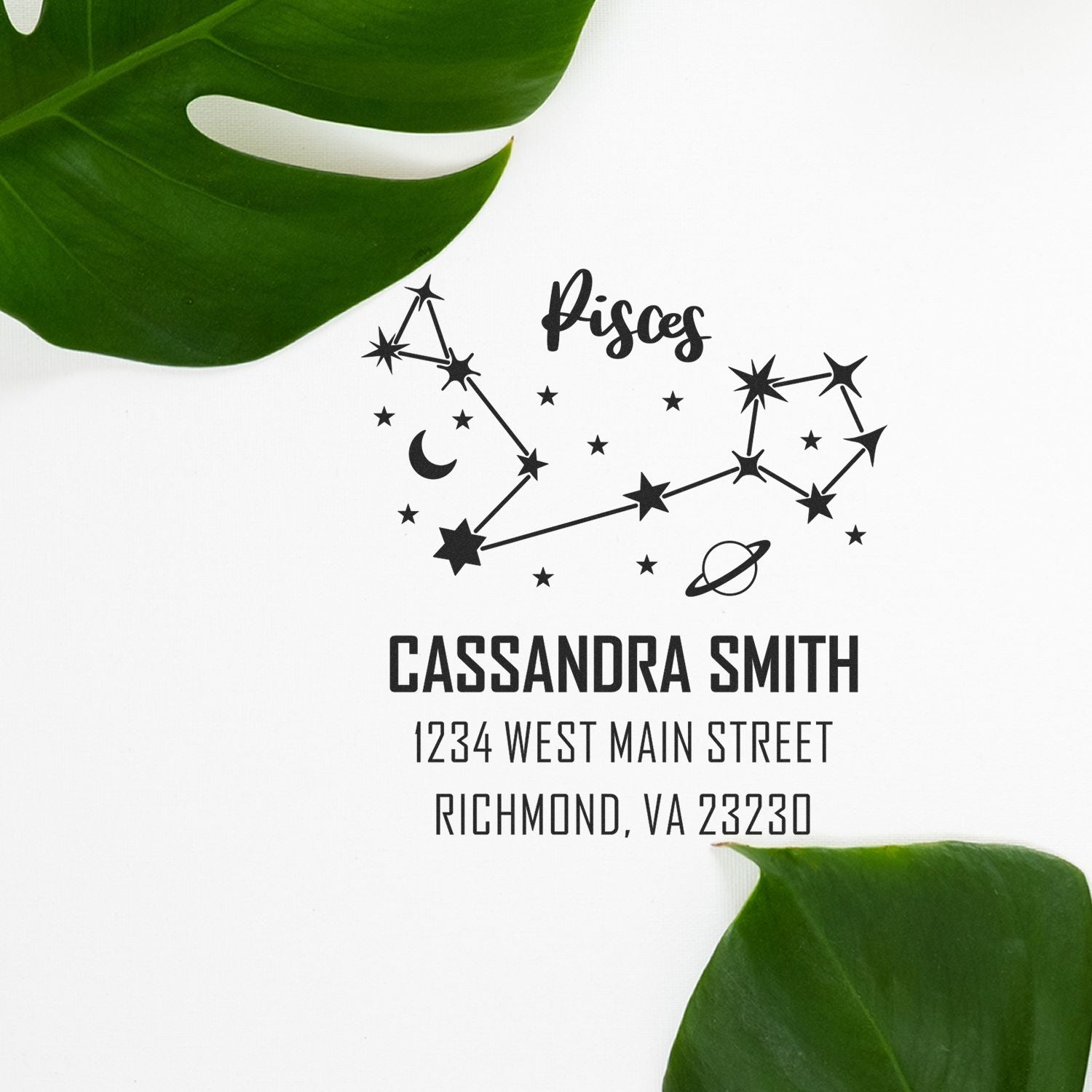 Custom black Pisces stamp and seal with constellation, Cassandra Smith name and address on white, framed by green leaves.