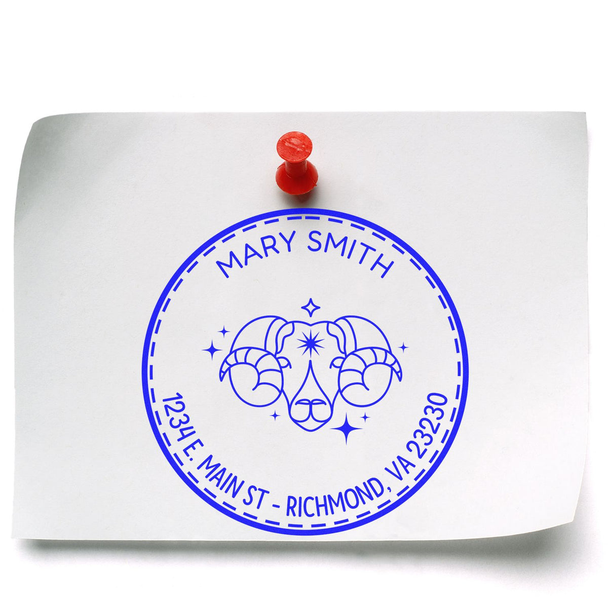 Blue circular custom stamp seal for Mary Smith with ram head emblem and address on white paper, held by a red push pin.