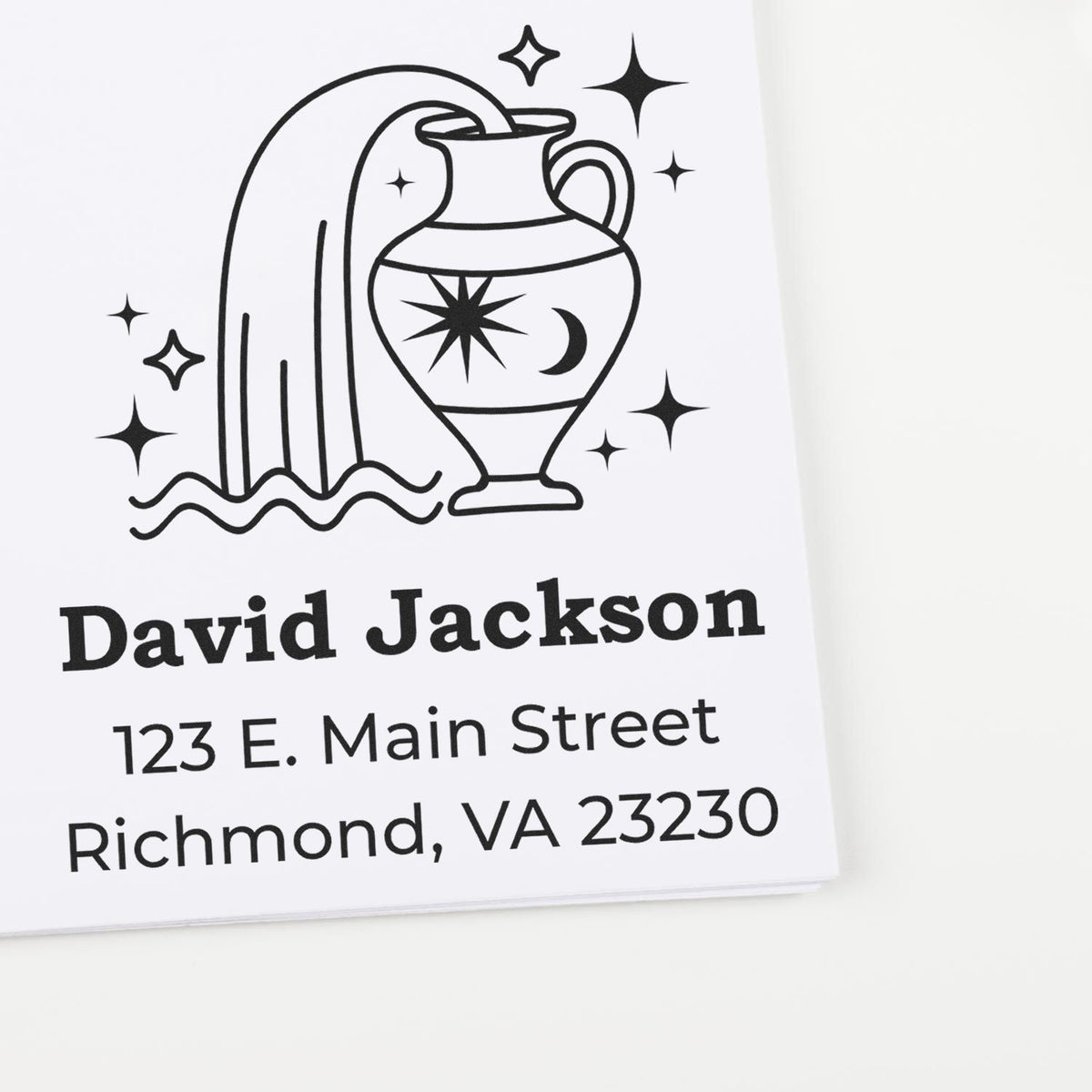 Black custom address stamp and seal featuring an urn, stars, and David Jackson address on white paper.