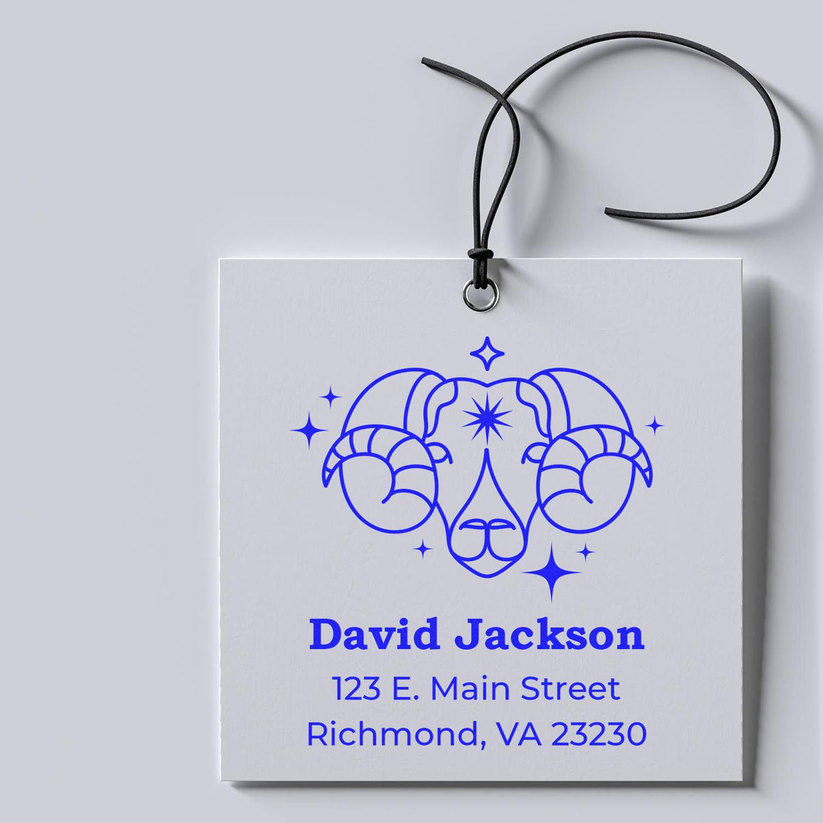 White custom stamp and seal tag with blue ram-head logo, David Jackson name, and Richmond, VA address on a black cord.
