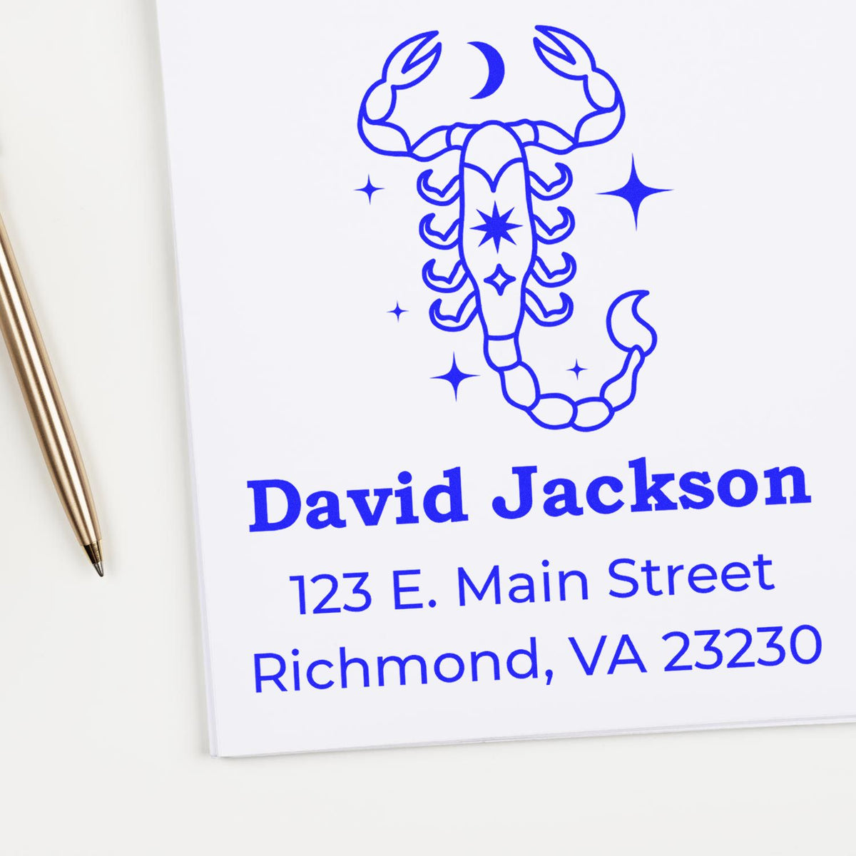 Blue scorpion custom stamp and seal with David Jackson name and Richmond address on white paper, beside a gold pen.