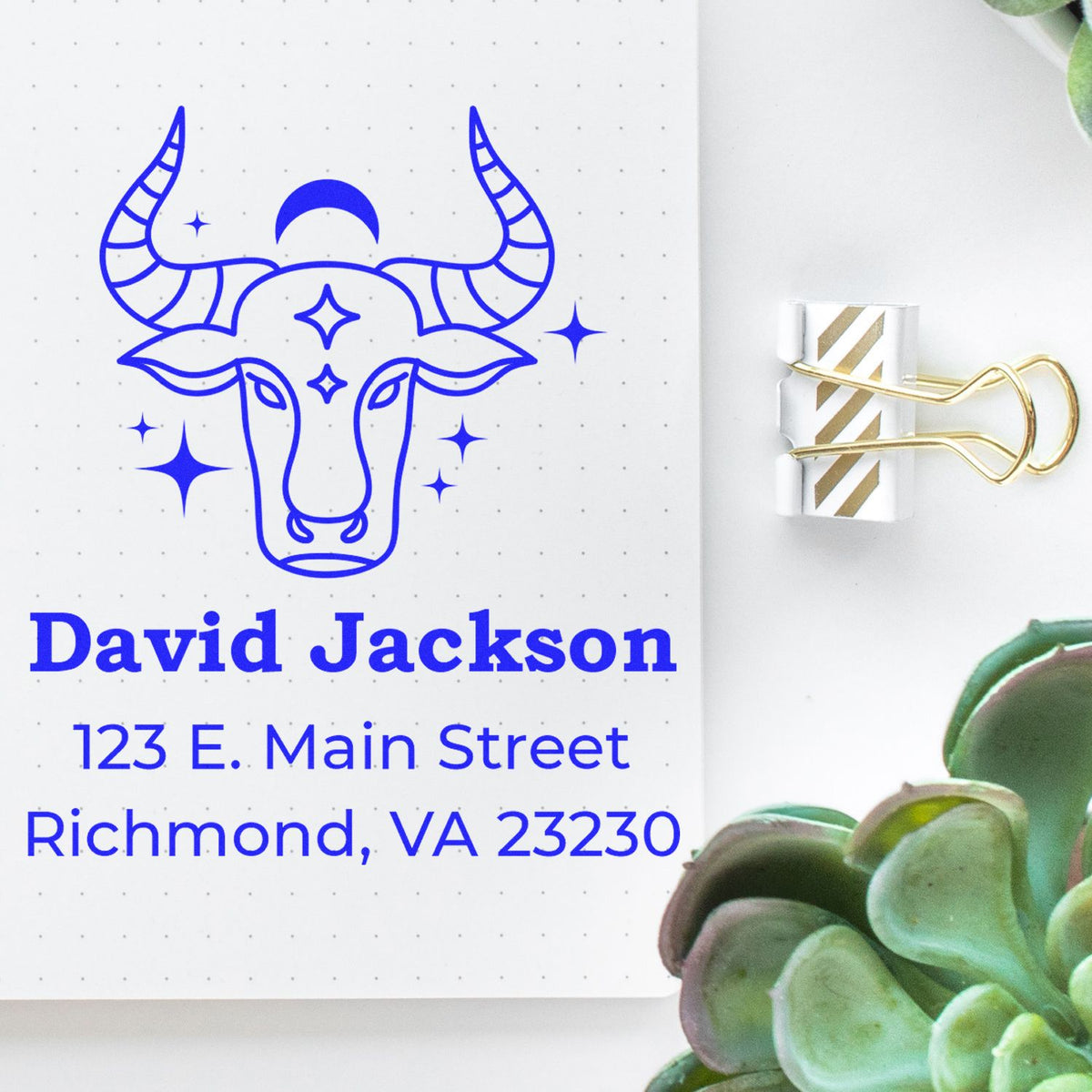 Blue custom bull stamp seal with stars and address on dotted white paper, clipped with a gold binder clip.
