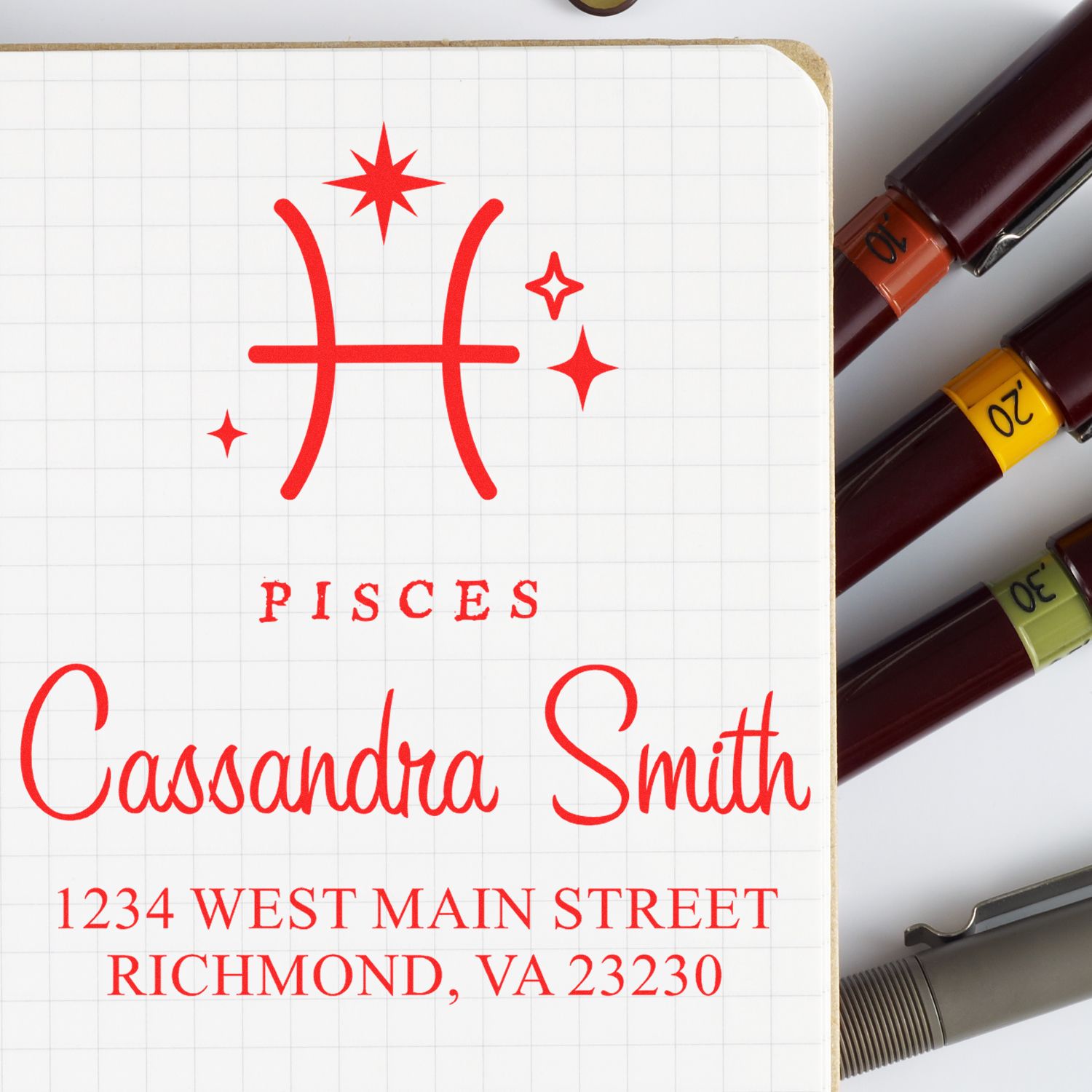 Red Pisces stamp and seal design with Cassandra Smith name, Richmond address, and burgundy markers with colored bands.