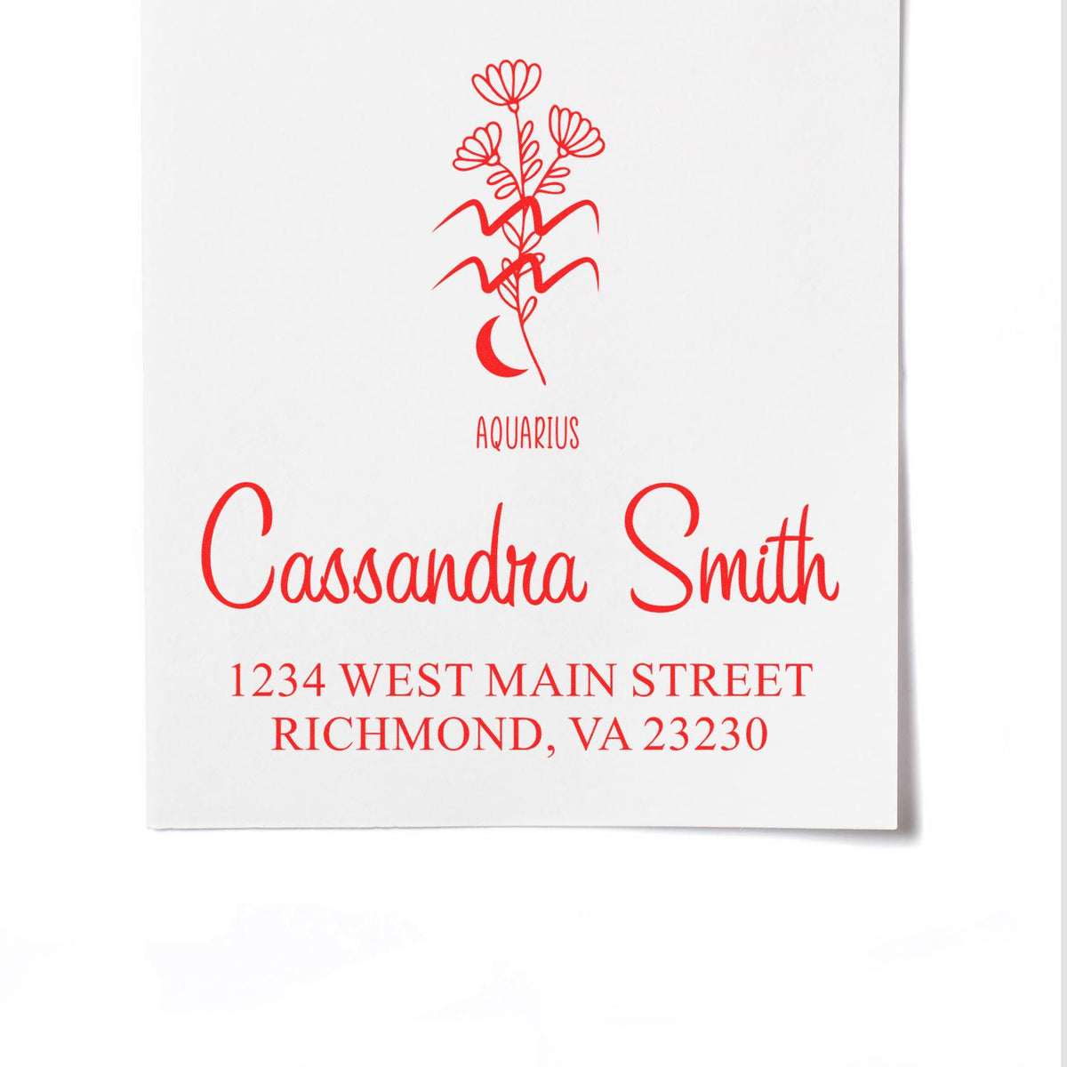 Red Aquarius custom return address stamp with floral seal, Cassandra Smith name, and Richmond, VA address on white paper.
