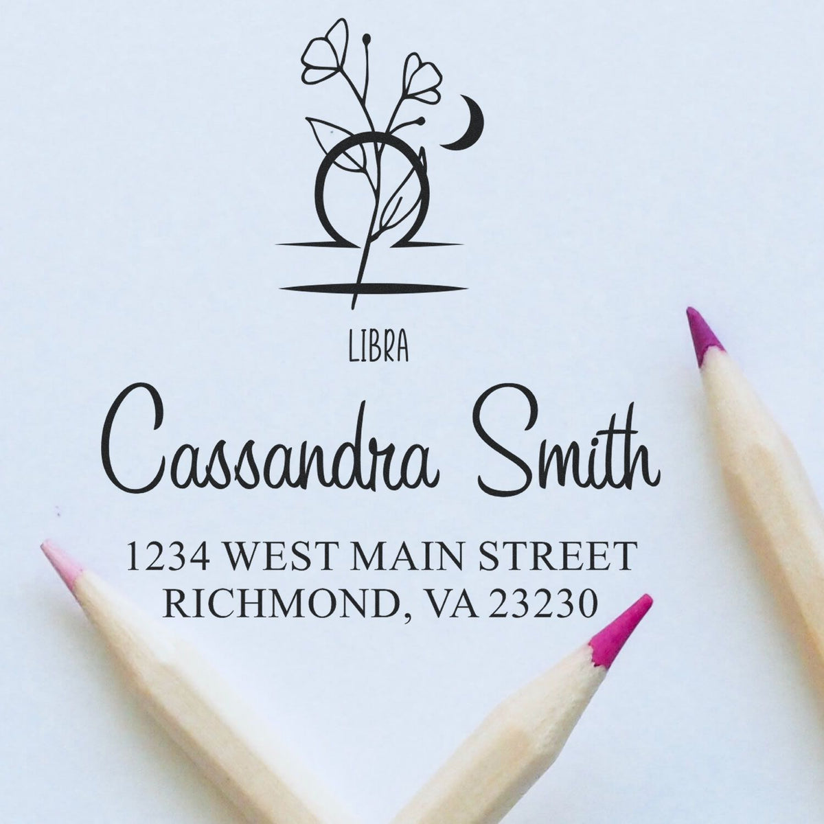 Black Libra floral stamp and seal with Cassandra Smith name and Richmond, VA address on white paper, framed by pink-tipped pencils.