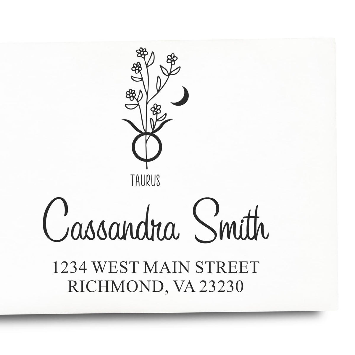 Black custom Taurus return-address stamp with floral moon emblem, Cassandra Smith, and Richmond, VA address on white paper.