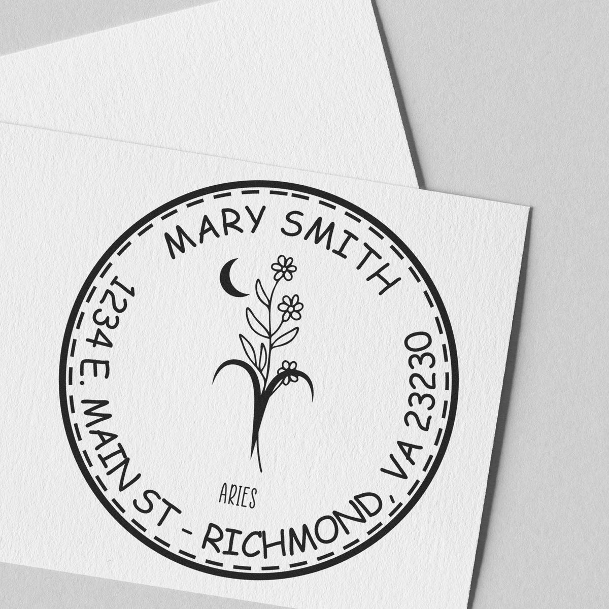 Black custom circular stamp seal featuring Mary Smith, Aries, floral sprig, and VA address on white paper.