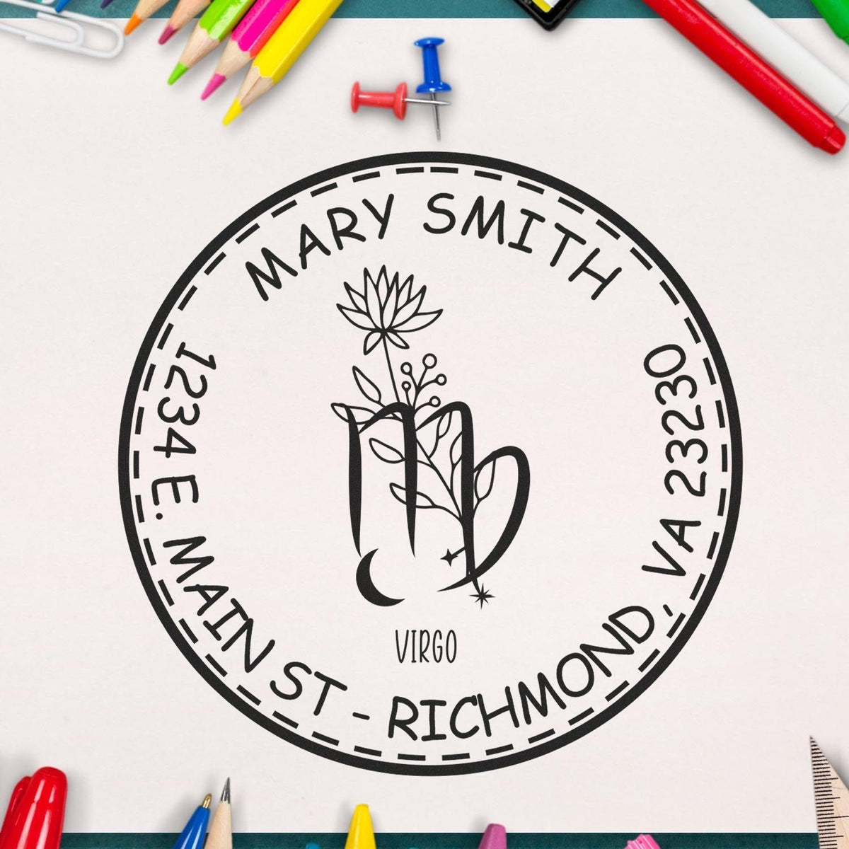 Black personalized round stamp seal for Mary Smith, Virgo floral mug design, with address, on white amid colorful pencils.