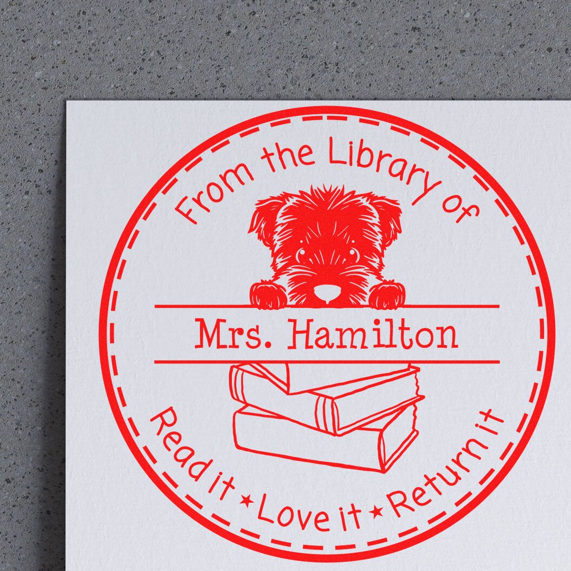 Red custom library stamp seal with puppy and books, labeled Mrs. Hamilton on white paper.