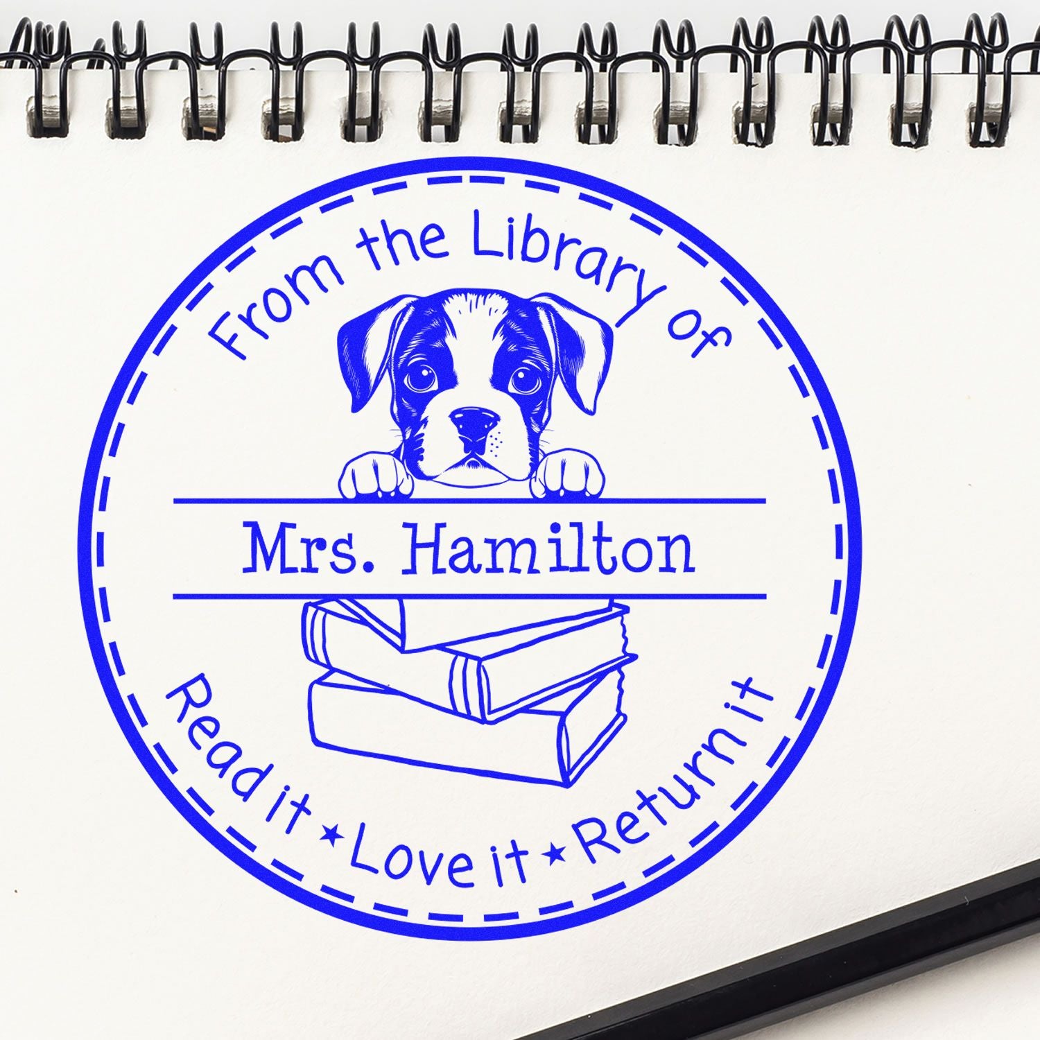 Custom blue circular library stamp and seal with puppy over books, From the Library of Mrs. Hamilton, and return reminder.