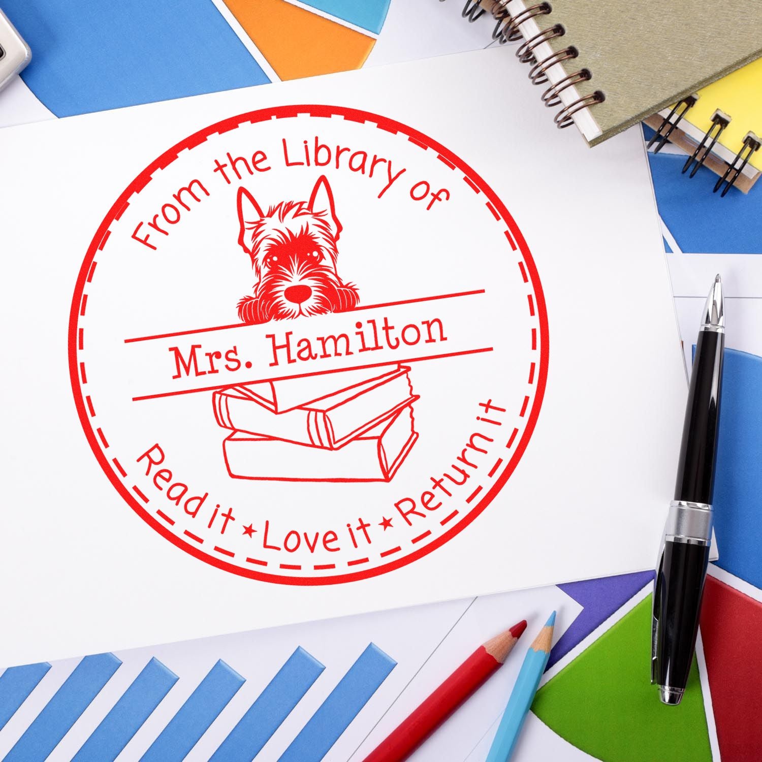 Red custom library return stamp seal for Mrs. Hamilton, with dog and books, on colorful stationery and pens.