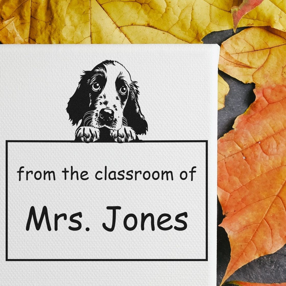Black dog classroom stamp seal reading from the classroom of Mrs. Jones on white paper, with yellow and orange leaves.