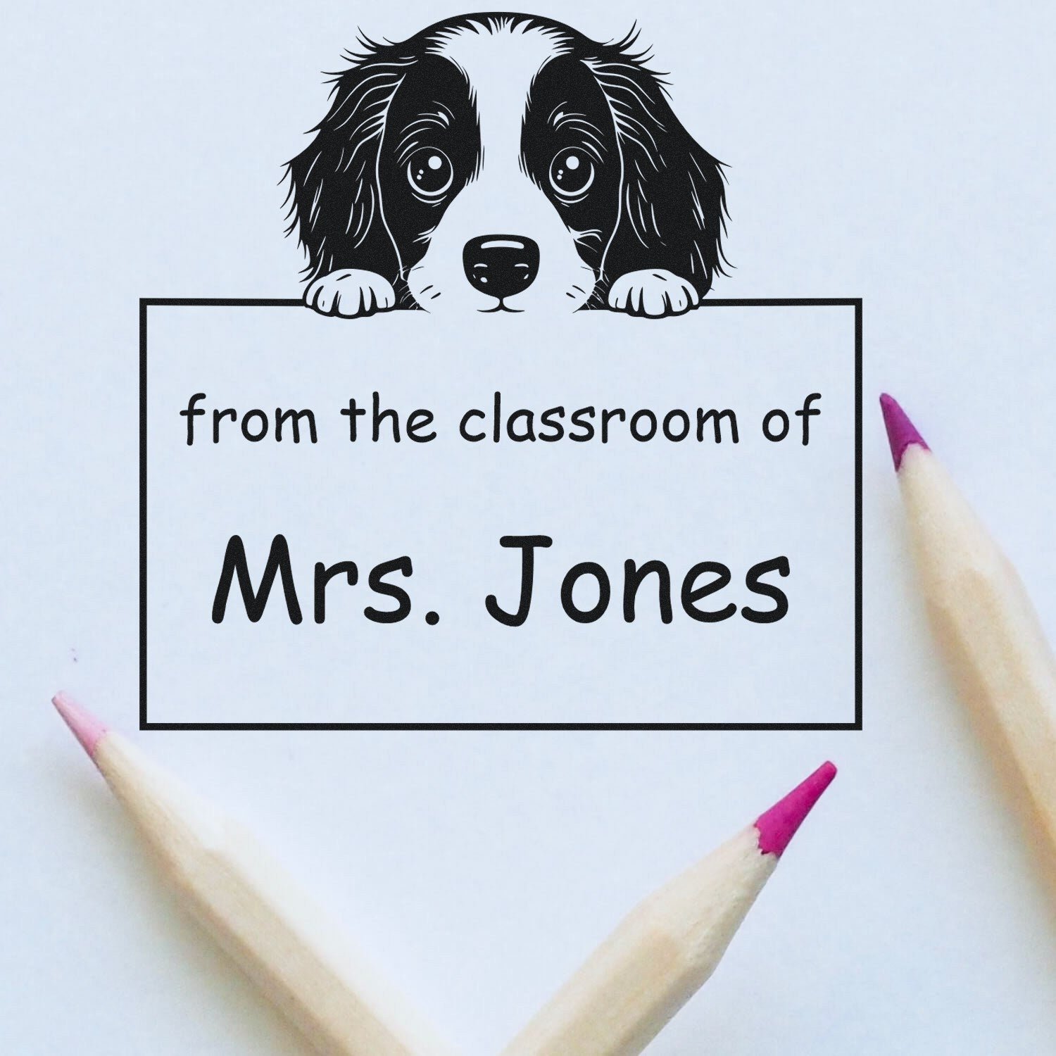 Black dog classroom stamp and seal reading from the classroom of Mrs. Jones, framed by pink pencil tips on white.