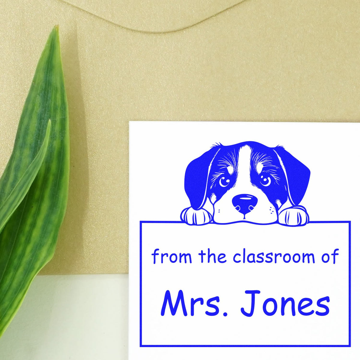 Blue puppy classroom stamp and seal reading from the classroom of Mrs. Jones on a white card, with green leaf accent