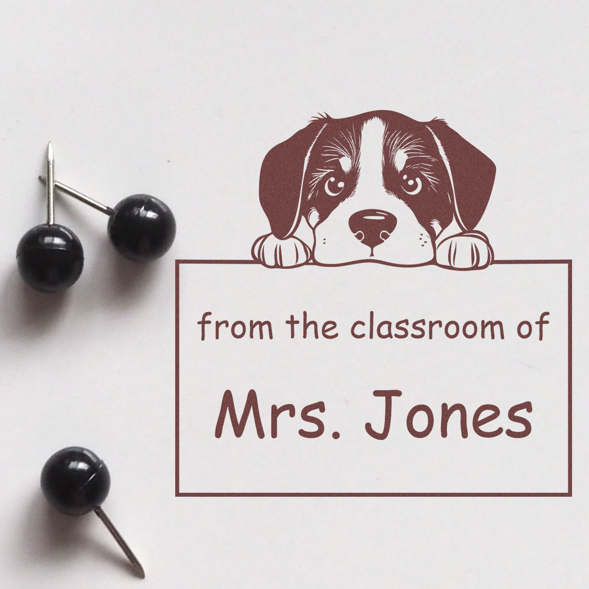 Brown custom classroom stamp seal with puppy graphic and from the classroom of Mrs. Jones; black pin handles.