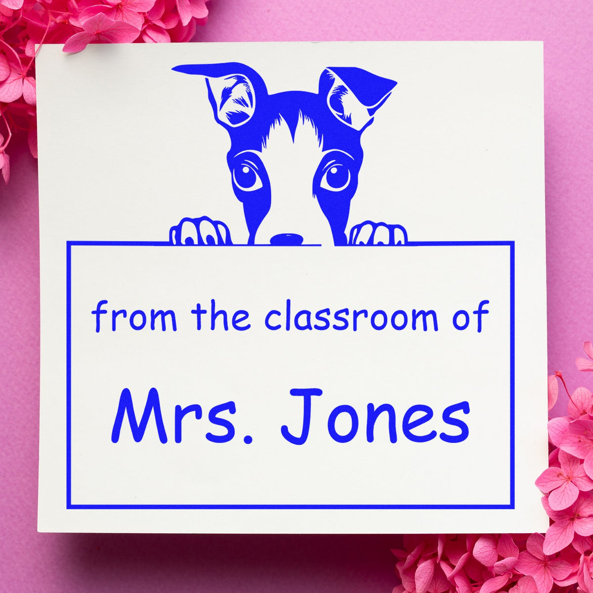 Blue dog classroom stamp and seal reading from the classroom of Mrs. Jones on white paper with pink floral accents.