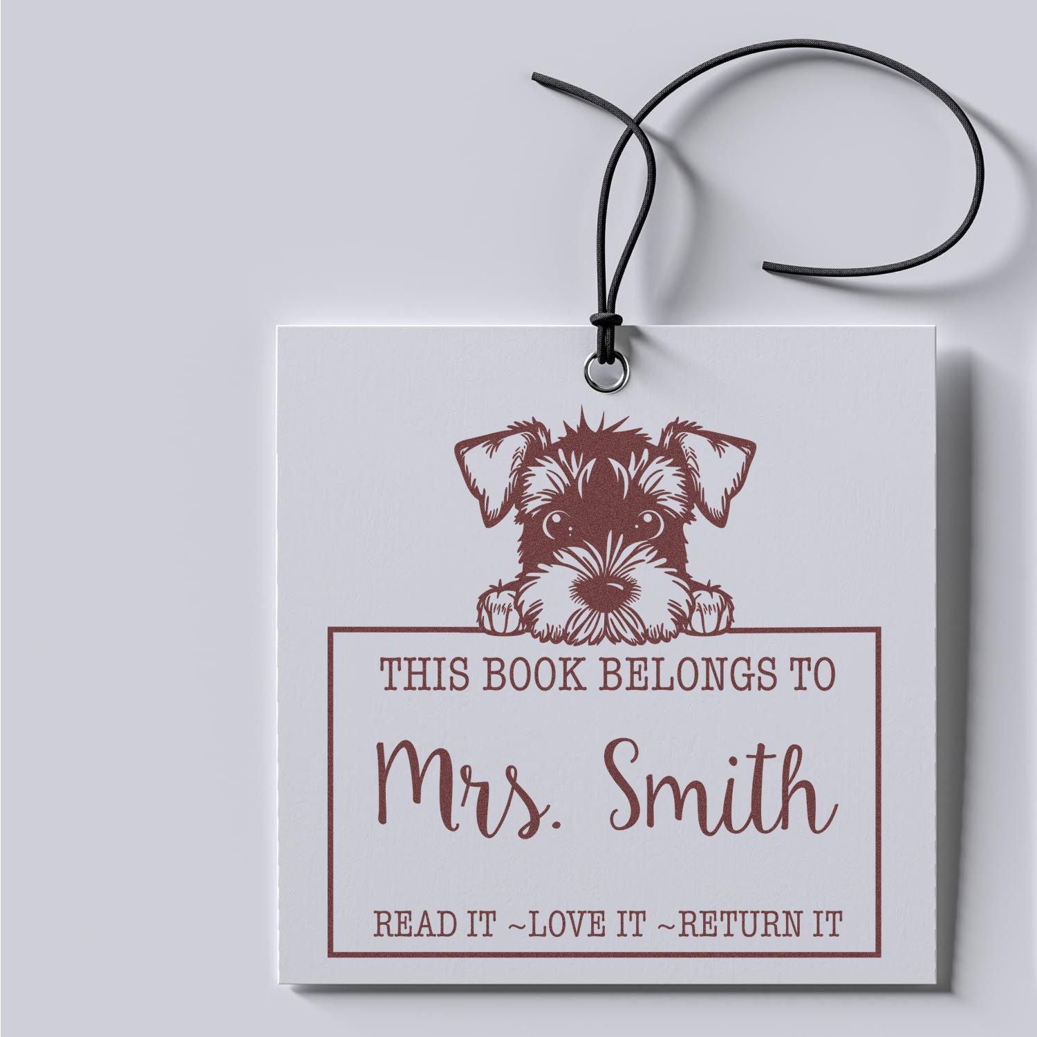 White book return stamp seal with brown dog and This Book Belongs to Mrs. Smith text, black hanging cord