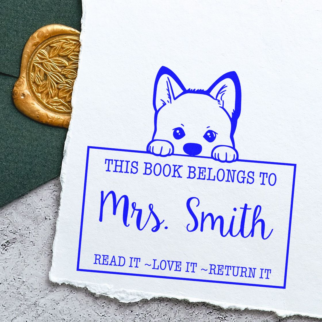 Blue custom book stamp with puppy illustration and Mrs. Smith text beside a gold decorative wax seal.