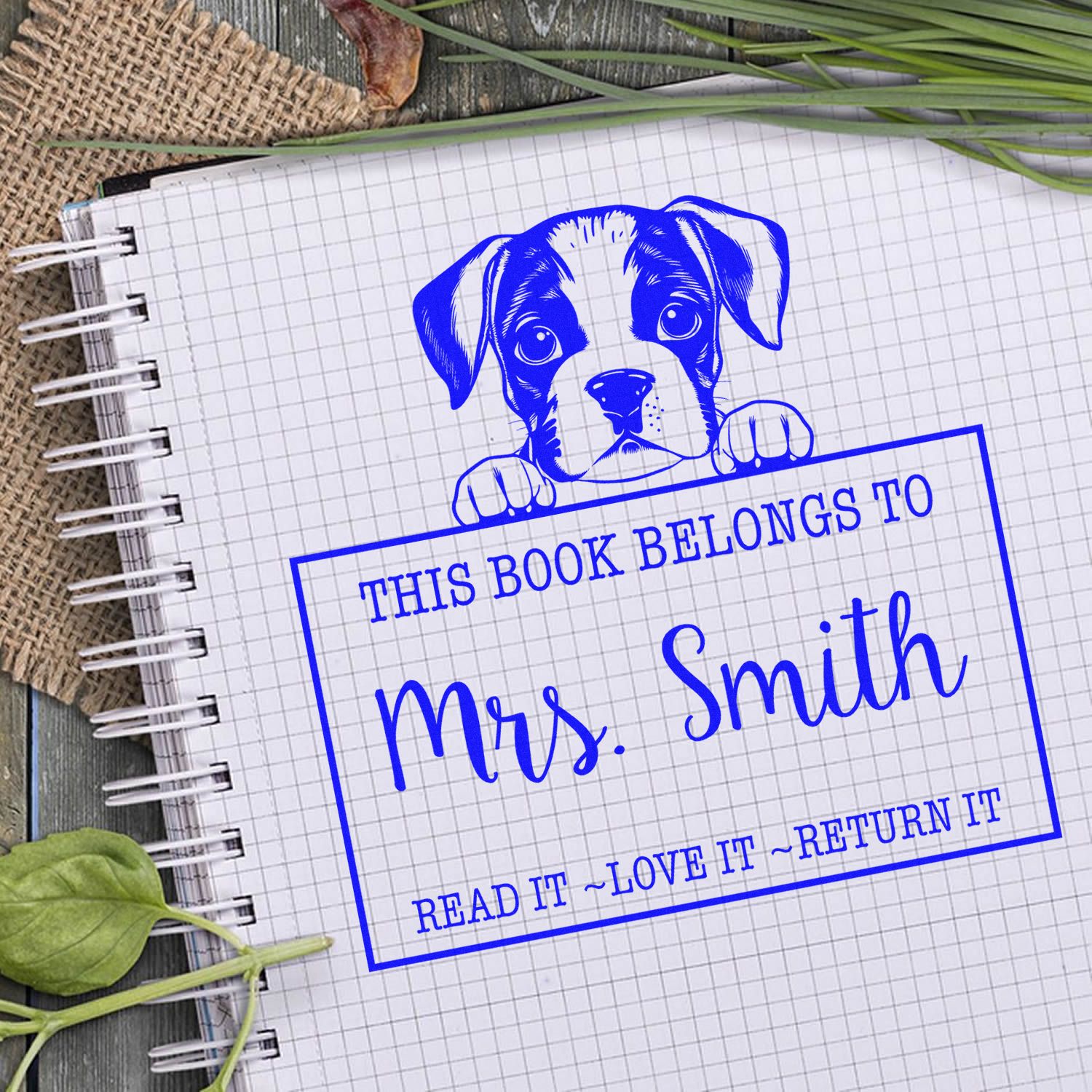 Blue custom book stamp and seal with puppy, This book belongs to Mrs. Smith, on a grid notebook.