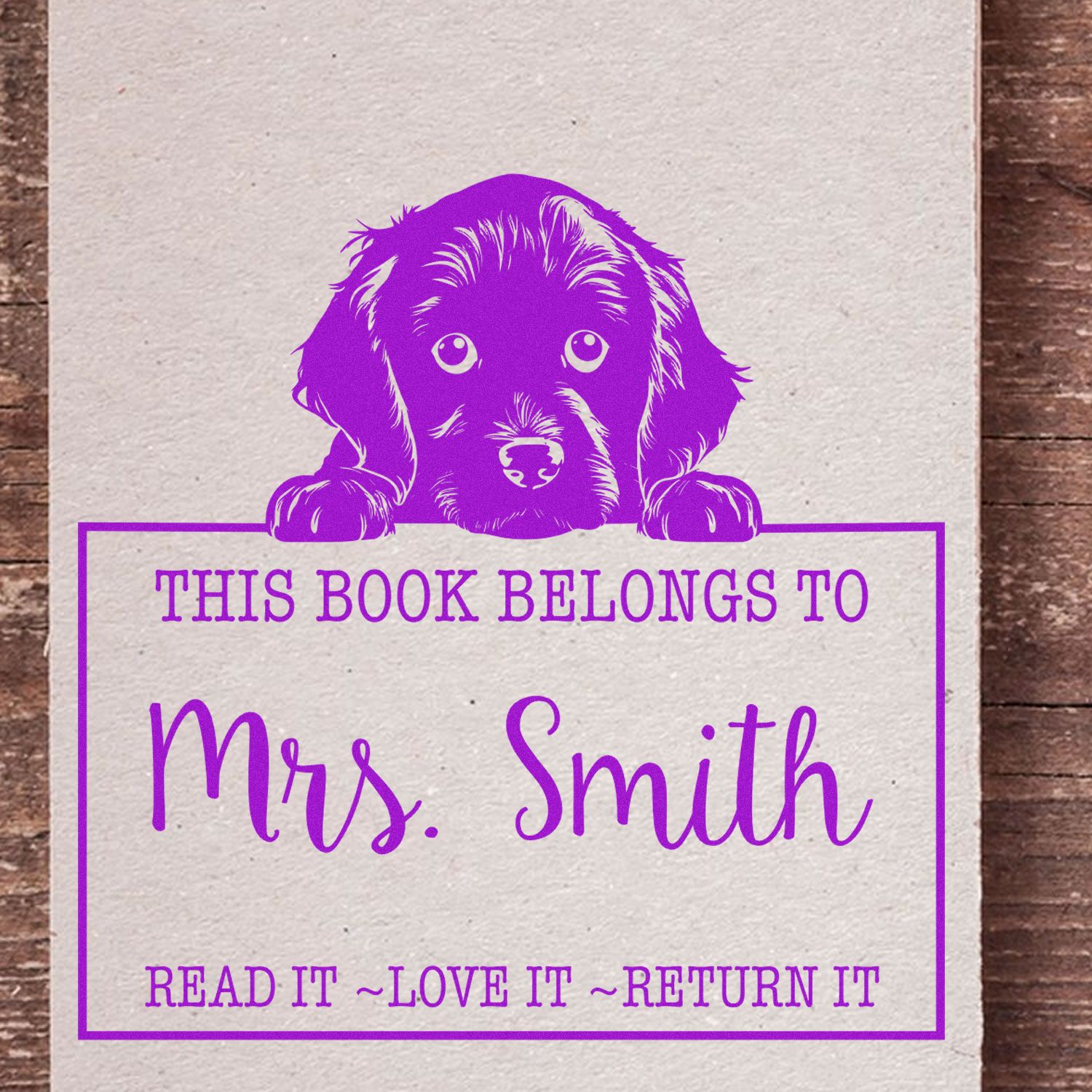 Purple personalized book stamp with puppy and Mrs. Smith name, reading Read it, love it, return it.