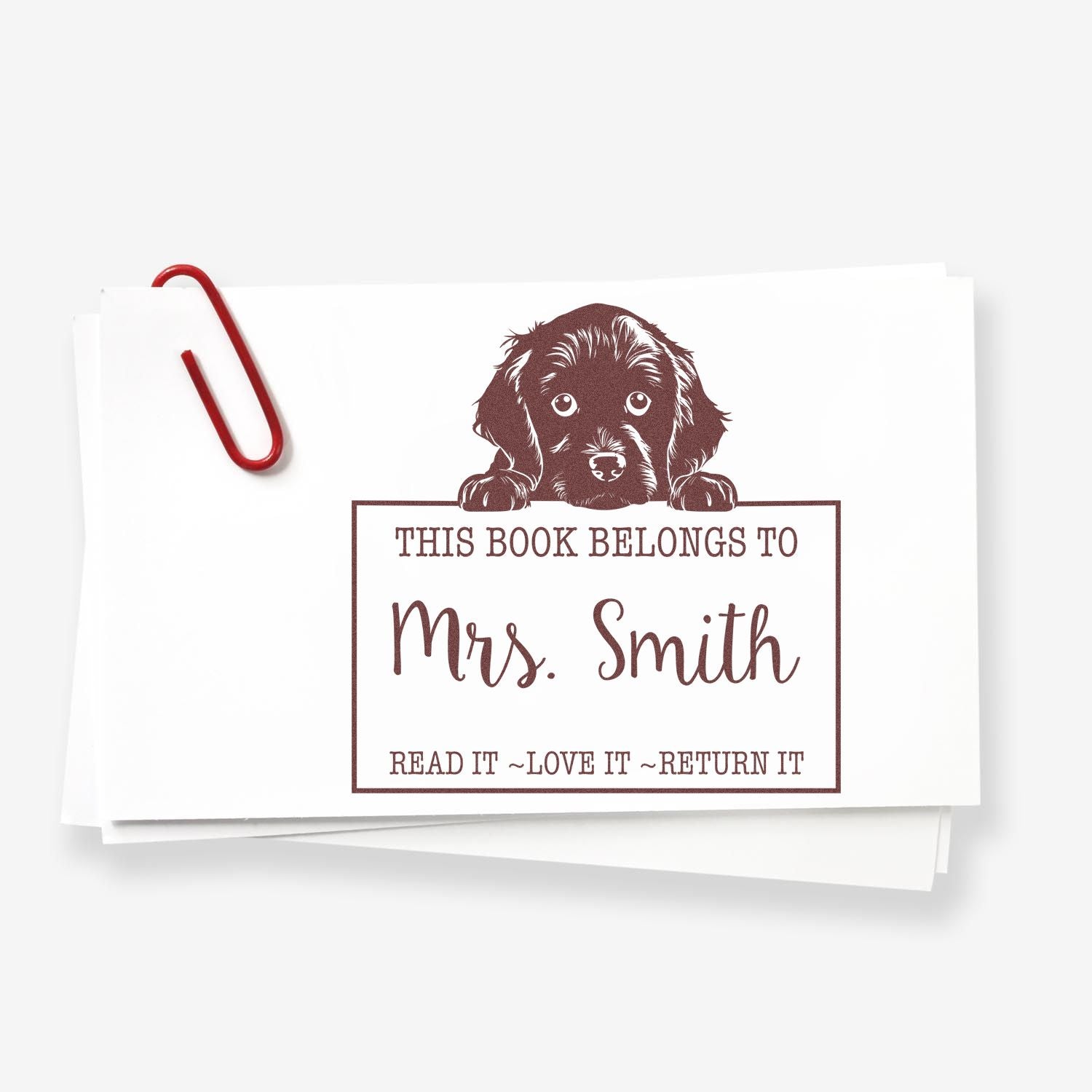 Brown dog book stamp seal reading This Book Belongs to Mrs. Smith on white cards, with a red paperclip.