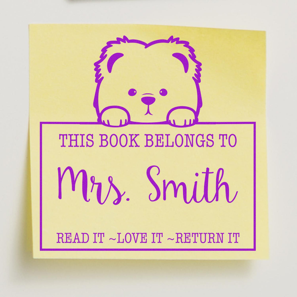 Purple personalized bookplate stamp with bear on pale yellow, reading This book belongs to Mrs. Smith.