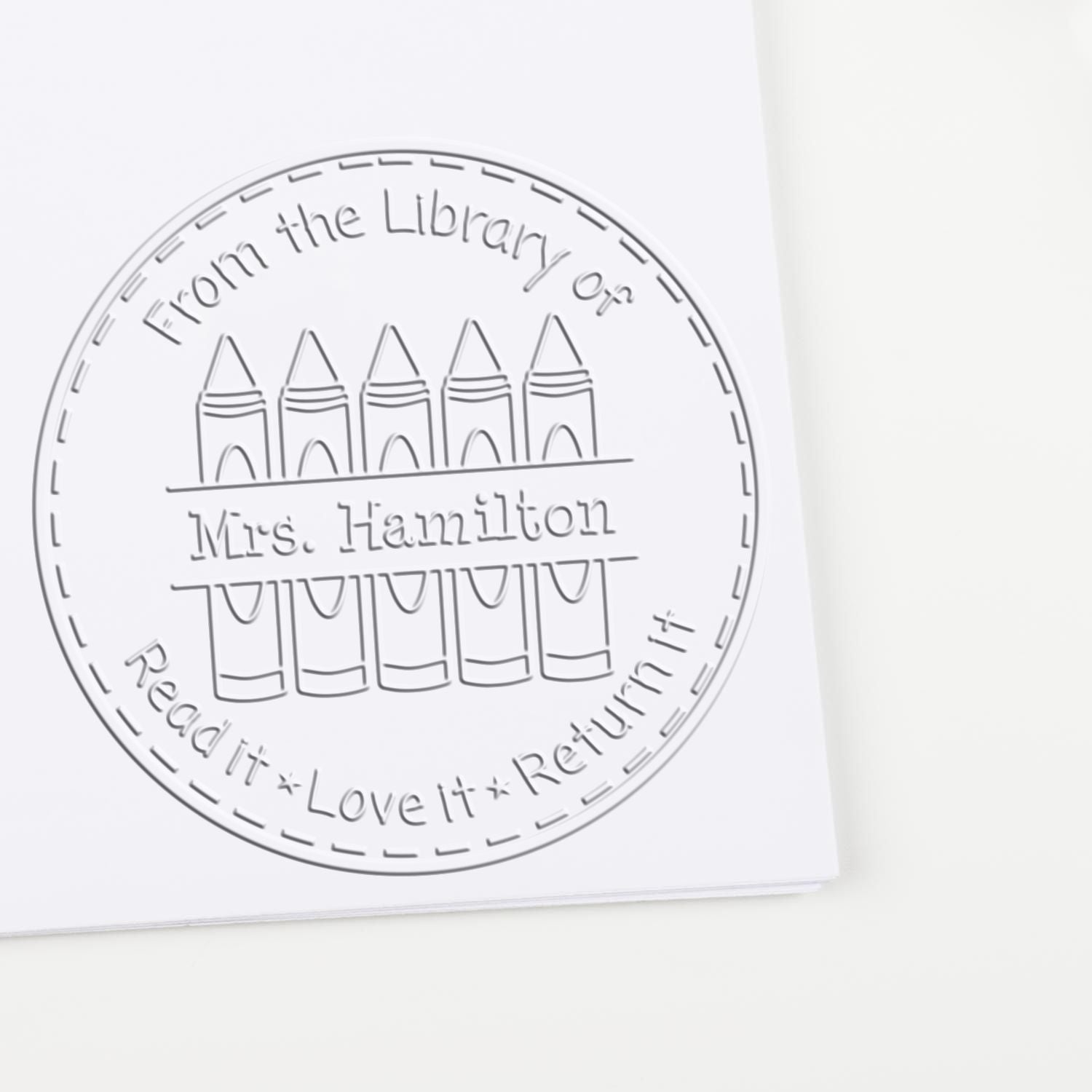 Circular gray library stamp seal with books and text: From the Library of Mrs. Hamilton Read it, Love it, Return it.