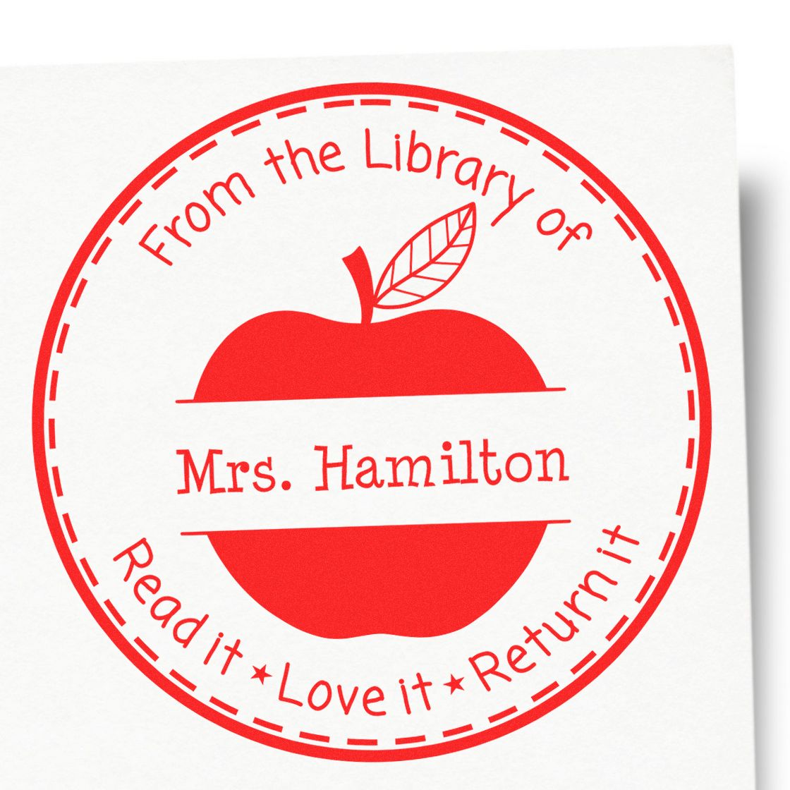 Red circular library stamp seal with apple logo, Mrs. Hamilton, and Read it, Love it, Return it text.
