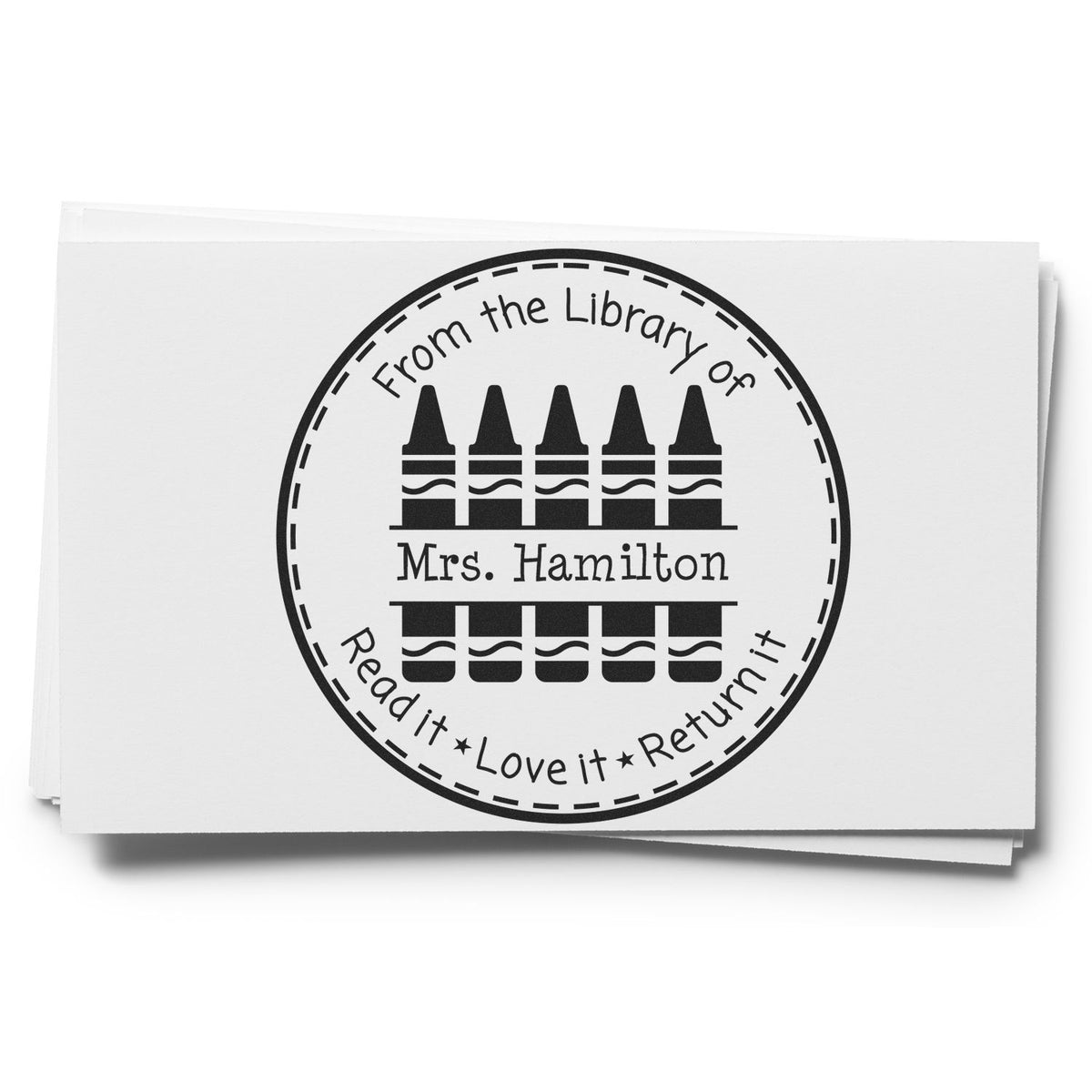 Black circular library stamp seal with crayon icons, From the Library of Mrs. Hamilton and Read it Love it Return it on white paper.