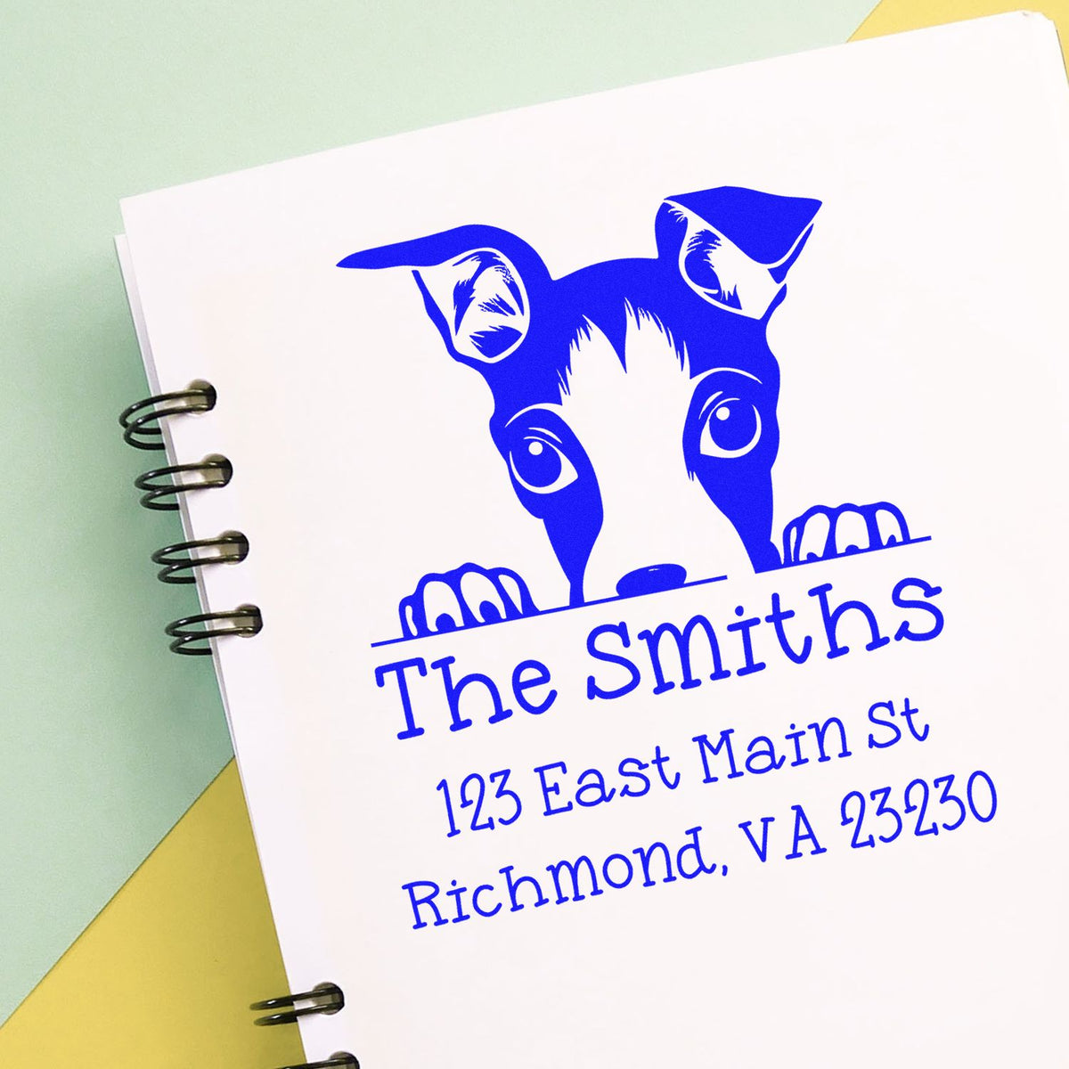 Blue custom stamp and seal with dog logo for The Smiths on a white spiral notebook.