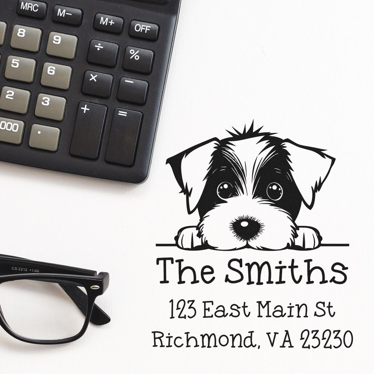 Custom black address stamp and seal with puppy graphic, The Smiths, and Richmond, VA, beside calculator and glasses.