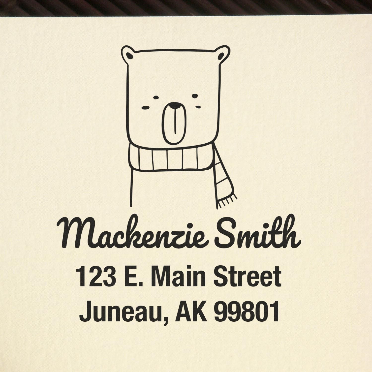 Wood handle snuggly bear cartoon animal made to order mail stamper with personalized mailing stamp design. Features a cute bear illustration wearing a scarf, alongside the name "Mackenzie Smith" and address details on a beige background.
