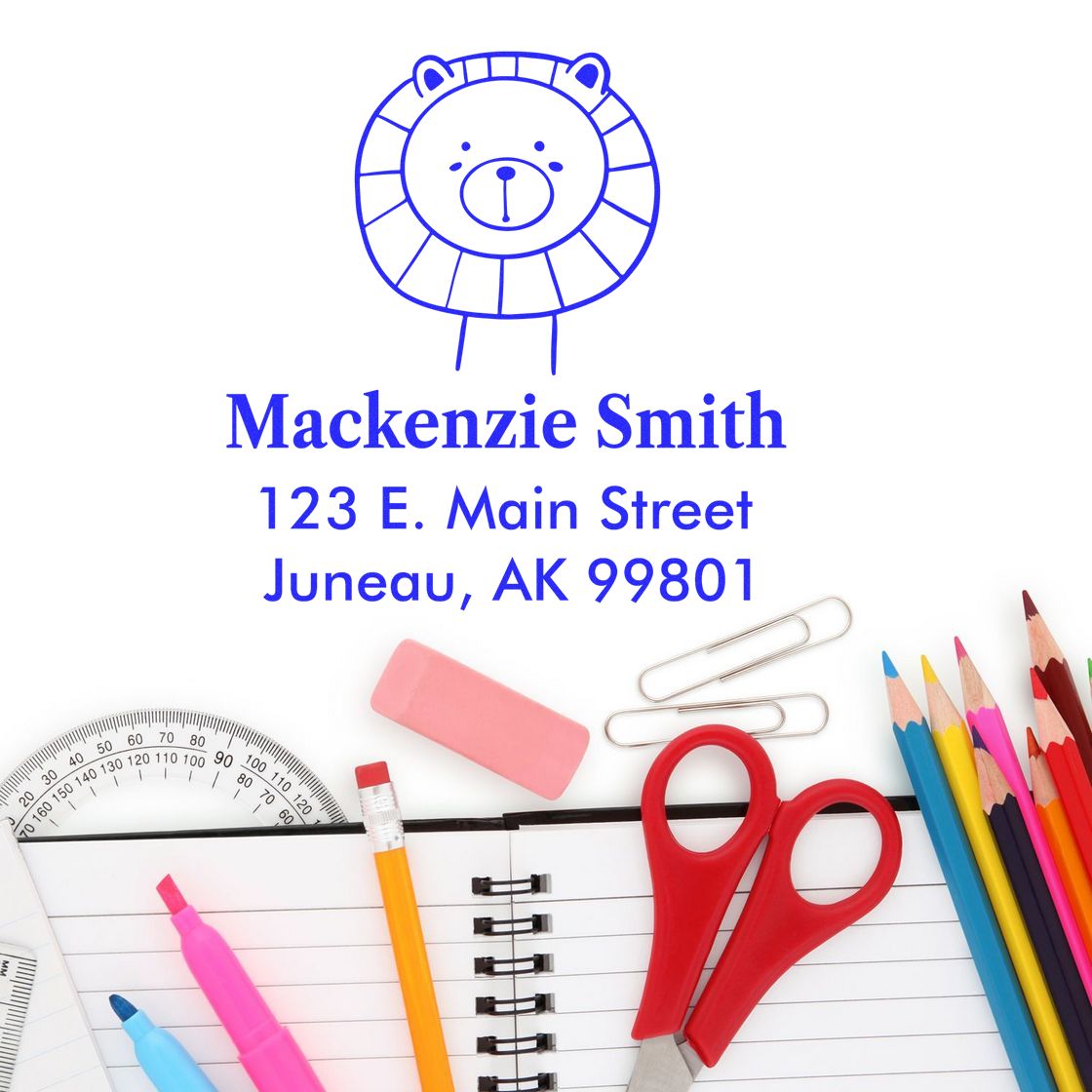 A Wood Handle Lovable Lion's Lair Cartoon Animal Made To Order Return Address Stamp is shown on paper with the name "Mackenzie Smith" and address. Surrounding items include colored pencils, scissors, and a notebook. Customizable New Address Stamp option.