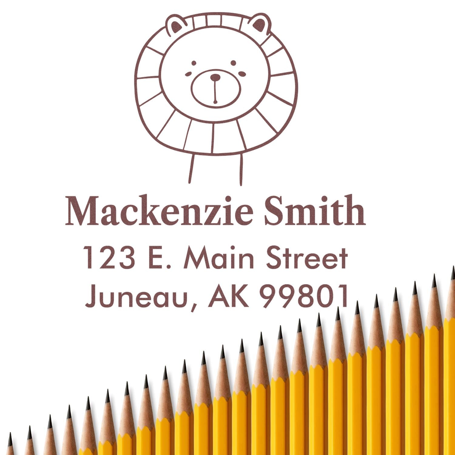 Portable Pre-Inked Lovable Lion's Lair Handcrafted New Home Stamper with a lion illustration, custom-made mailing stamp for Mackenzie Smith, 123 E. Main Street, Juneau, AK 99801, displayed above a row of yellow pencils.