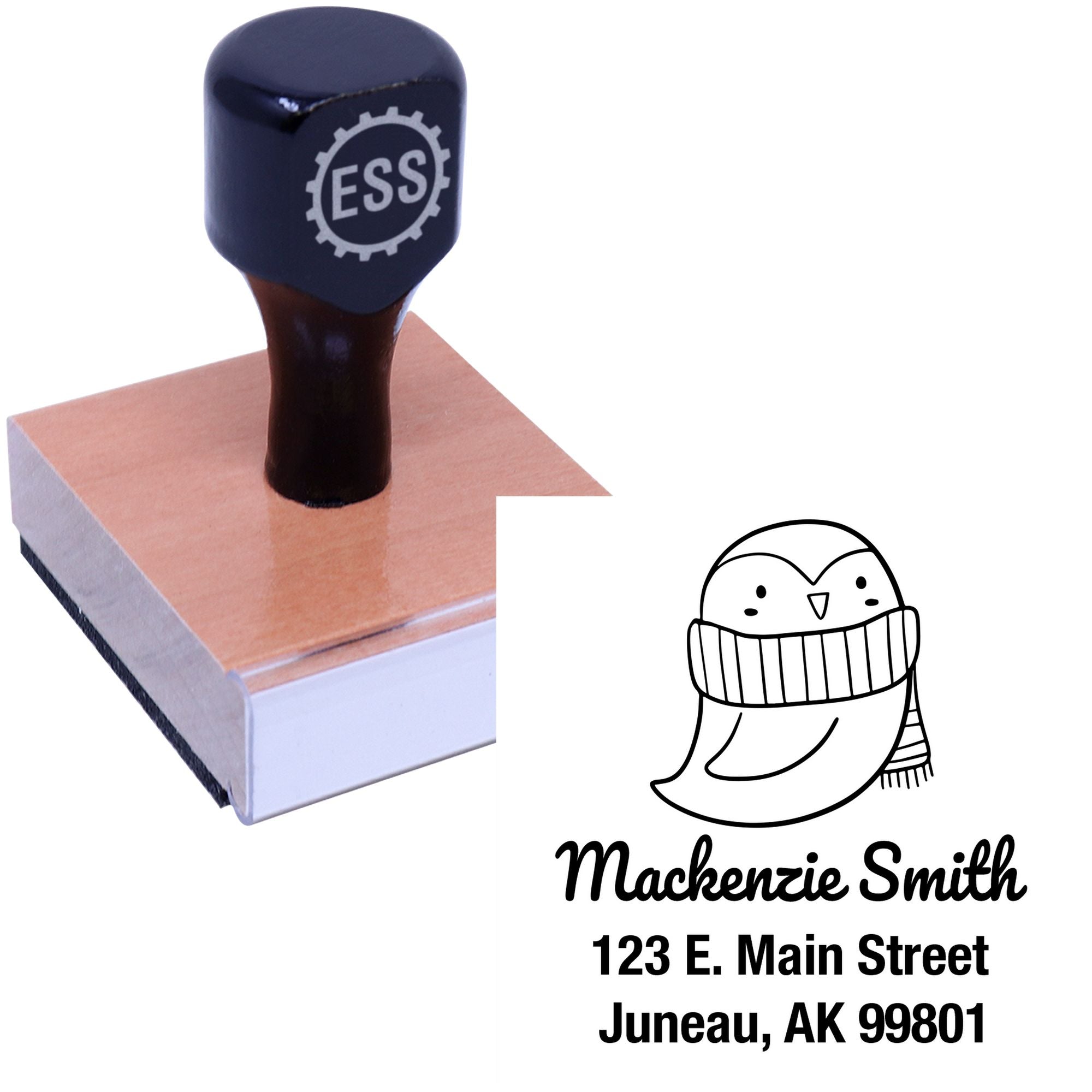 Wood handle stamp with a pretty penguin cartoon design, labeled "ESS." The custom-made new address stamper features the name "Mackenzie Smith" and address in Juneau, AK. Ideal for personalized mailing needs.