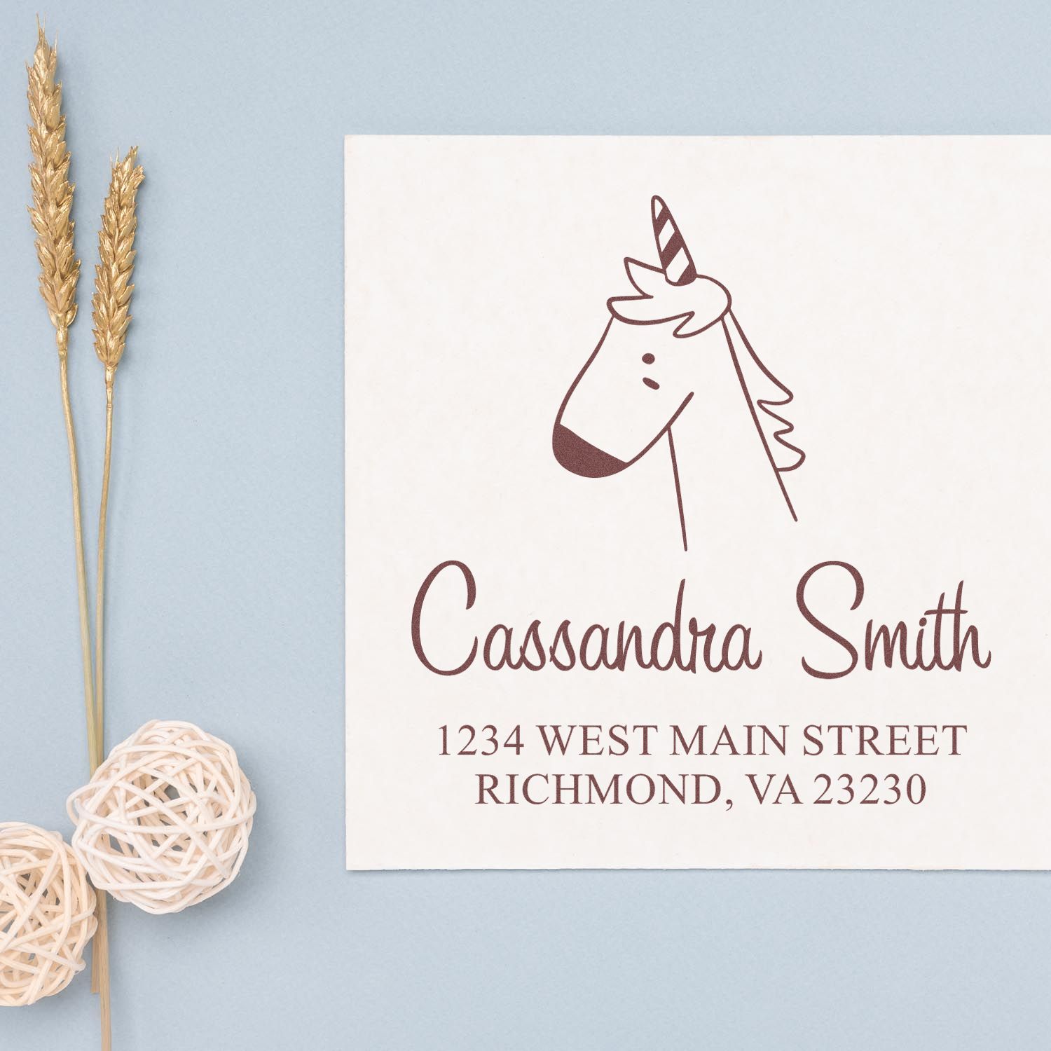 Portable Pre-Inked Whimsical Unicorn Custom Designed Address Stamper on a light blue background. The Customized Mailing Stamp displays "Cassandra Smith, 1234 West Main Street, Richmond, VA 23230" with a simple unicorn illustration.