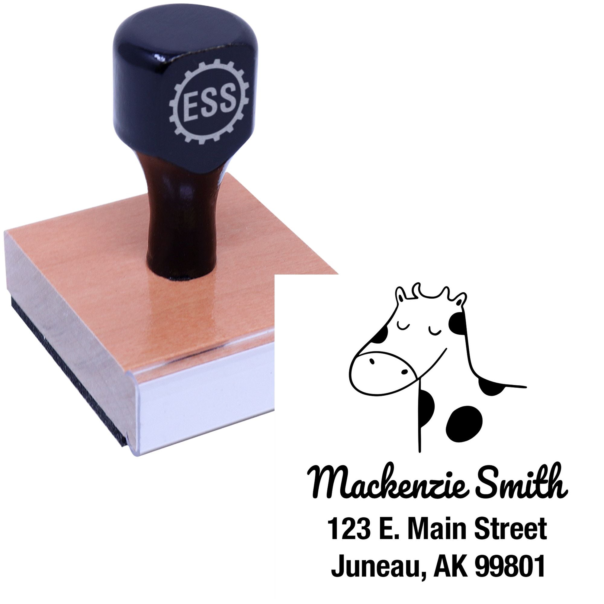 Wood handle stamper with a cartoon cow design labeled "Mackenzie Smith, 123 E. Main Street, Juneau, AK 99801." Features customizable mailing stamper options. Ideal for home use, made to order with cow cuddles theme.