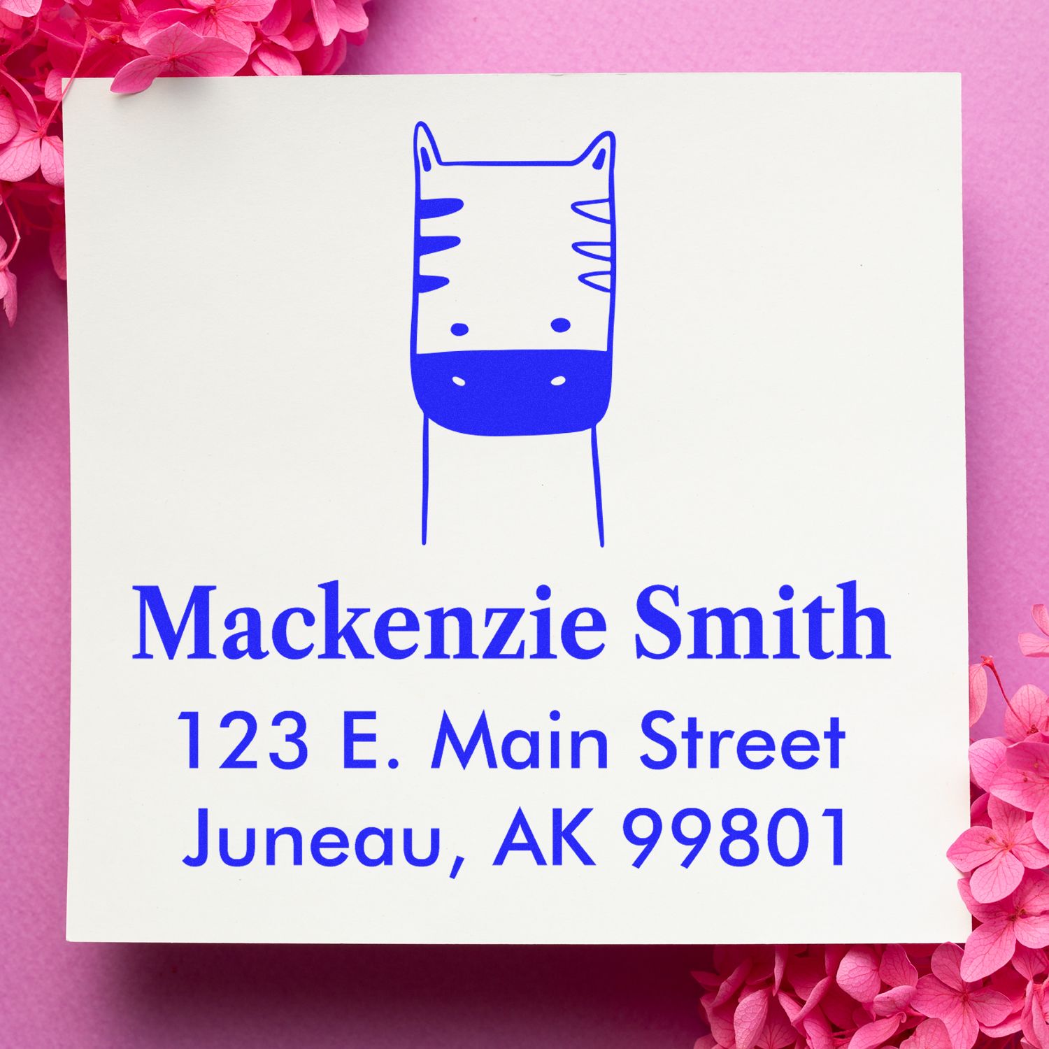 Self-Inking Cartoon Animal Frolicsome Zebra Custom Made Home Stamper on a pink background. The Personalizable Mailing Stamp features a playful zebra design with customizable address details, surrounded by pink flowers.