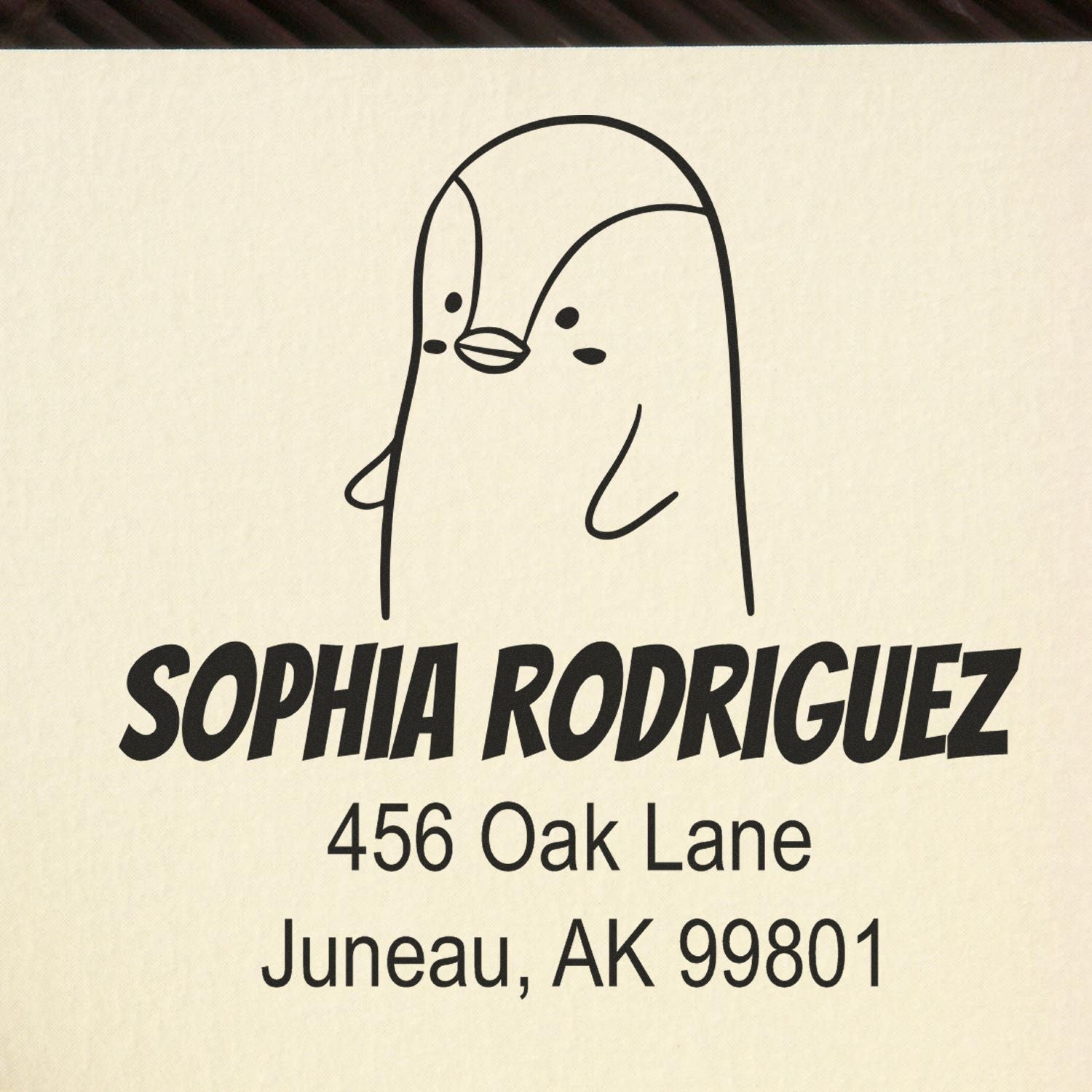 Wood handle perky penguin cartoon animal made to order address stamp featuring a custom mailing stamp design. The stamp shows a cute penguin above the name "Sophia Rodriguez" with an address in Juneau, AK.