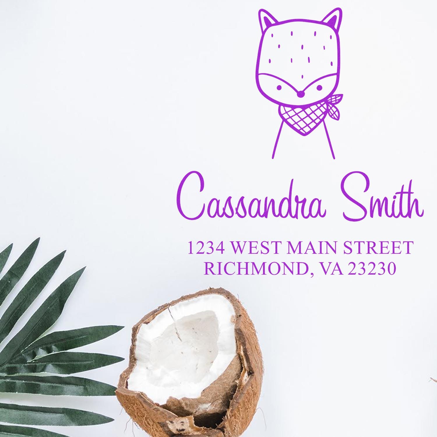 Portable Pre-Inked Fancy Fox Custom Designed Address Stamper with a fox illustration and the name "Cassandra Smith" above the address "1234 West Main Street, Richmond, VA 23230." Custom-Made Return Mail Stamper shown on a white background with a coconut and palm leaf.