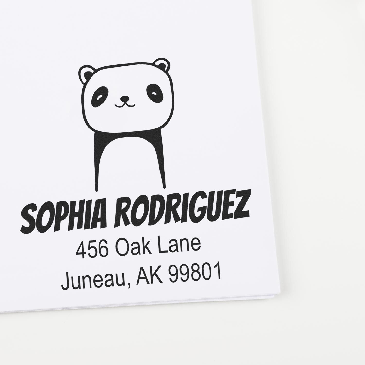 Self-Inking Cartoon Animal Playful Panda Custom Made Return Address Stamp on white paper. Personalizable Address Stamp with a cute panda design, featuring the name "Sophia Rodriguez" and address "456 Oak Lane, Juneau, AK 99801" in bold black text.