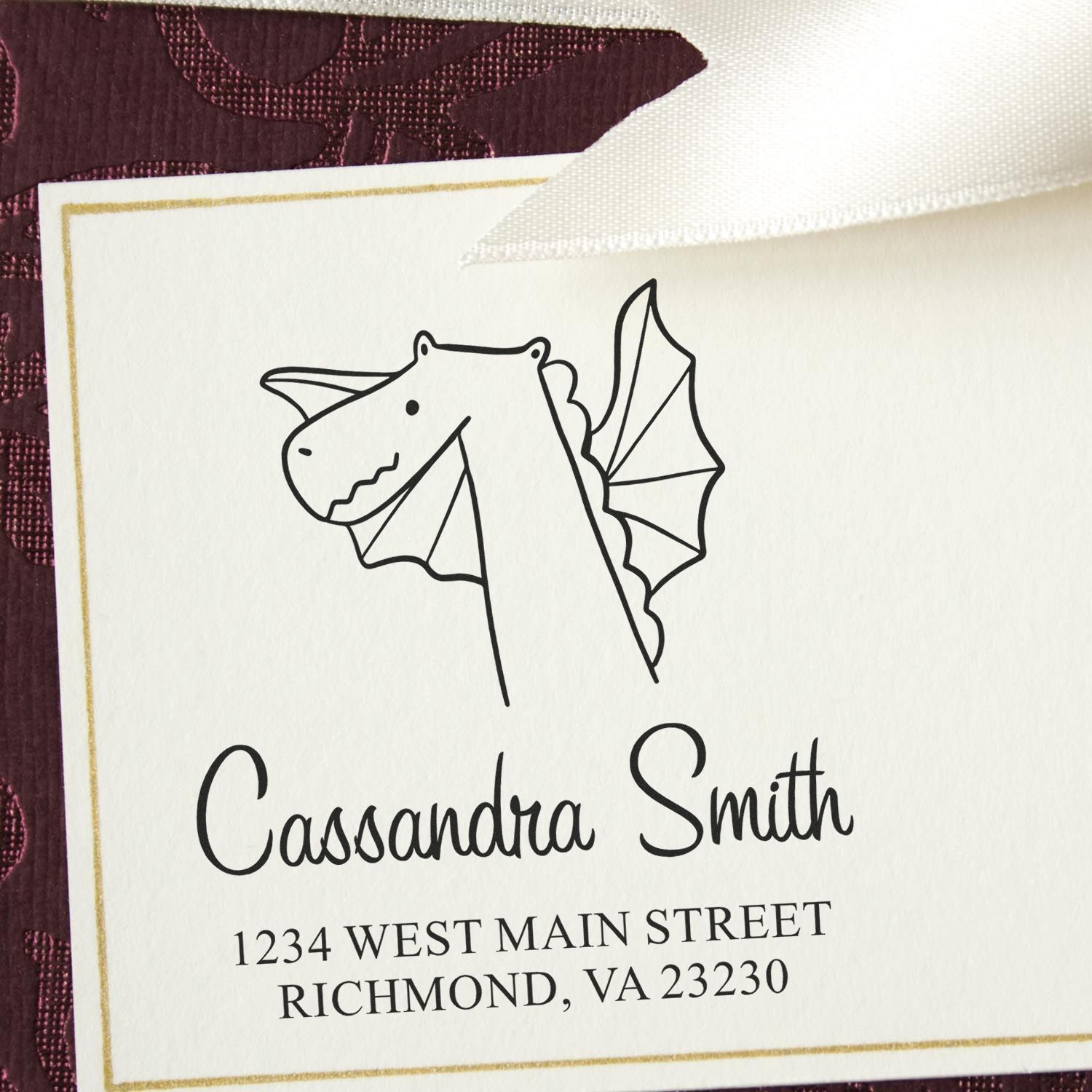 Wood Handle Dragon Delight Cartoon Animal Made To Order Return Address Stamper on an envelope. Features a dragon illustration with "Cassandra Smith, 1234 West Main Street, Richmond, VA 23230." Personalizable Home Stamp for custom use.