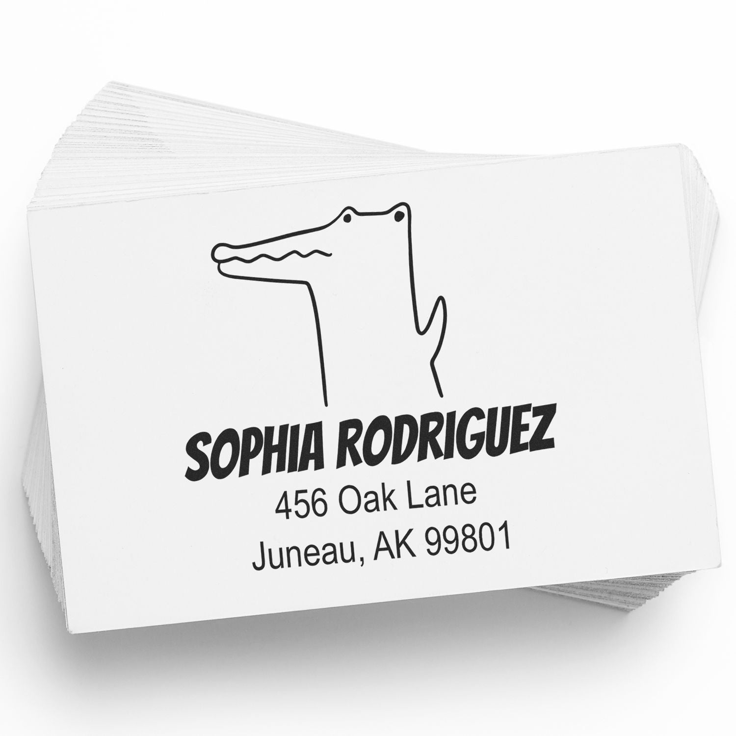 A stack of cards featuring a Portable Pre-Inked Charming Crocodile Made To Order Mail Stamp. The Custom Mailing Stamper displays a cartoon crocodile above the name "Sophia Rodriguez" with an address in Juneau, AK.