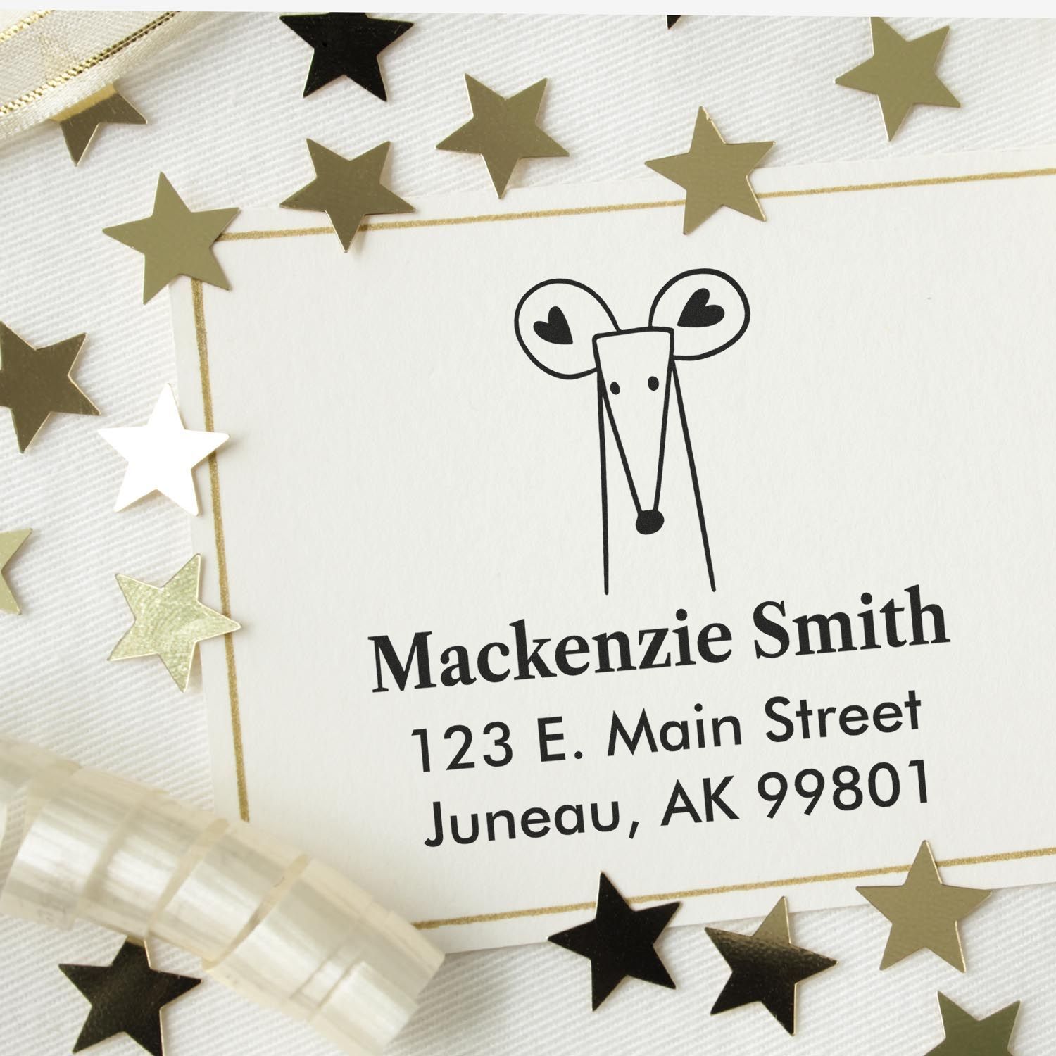 Portable Pre-Inked Mighty Mouse Made To Order Return Address Stamp used on a card with gold stars. The Custom Home Stamper displays "Mackenzie Smith, 123 E. Main Street, Juneau, AK 99801" in black text.
