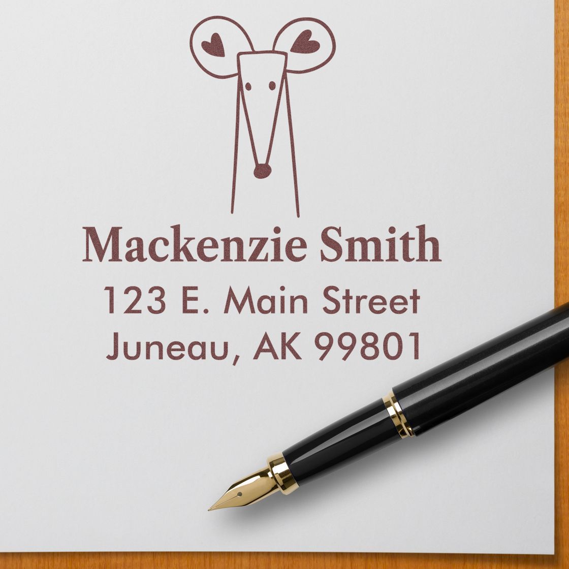 Self-Inking Cartoon Animal Mighty Mouse Personalized Home Address Stamp on white paper with "Mackenzie Smith, 123 E. Main Street, Juneau, AK 99801" in brown ink. Personalized Address Stamp design features a cute mouse with heart-shaped ears.