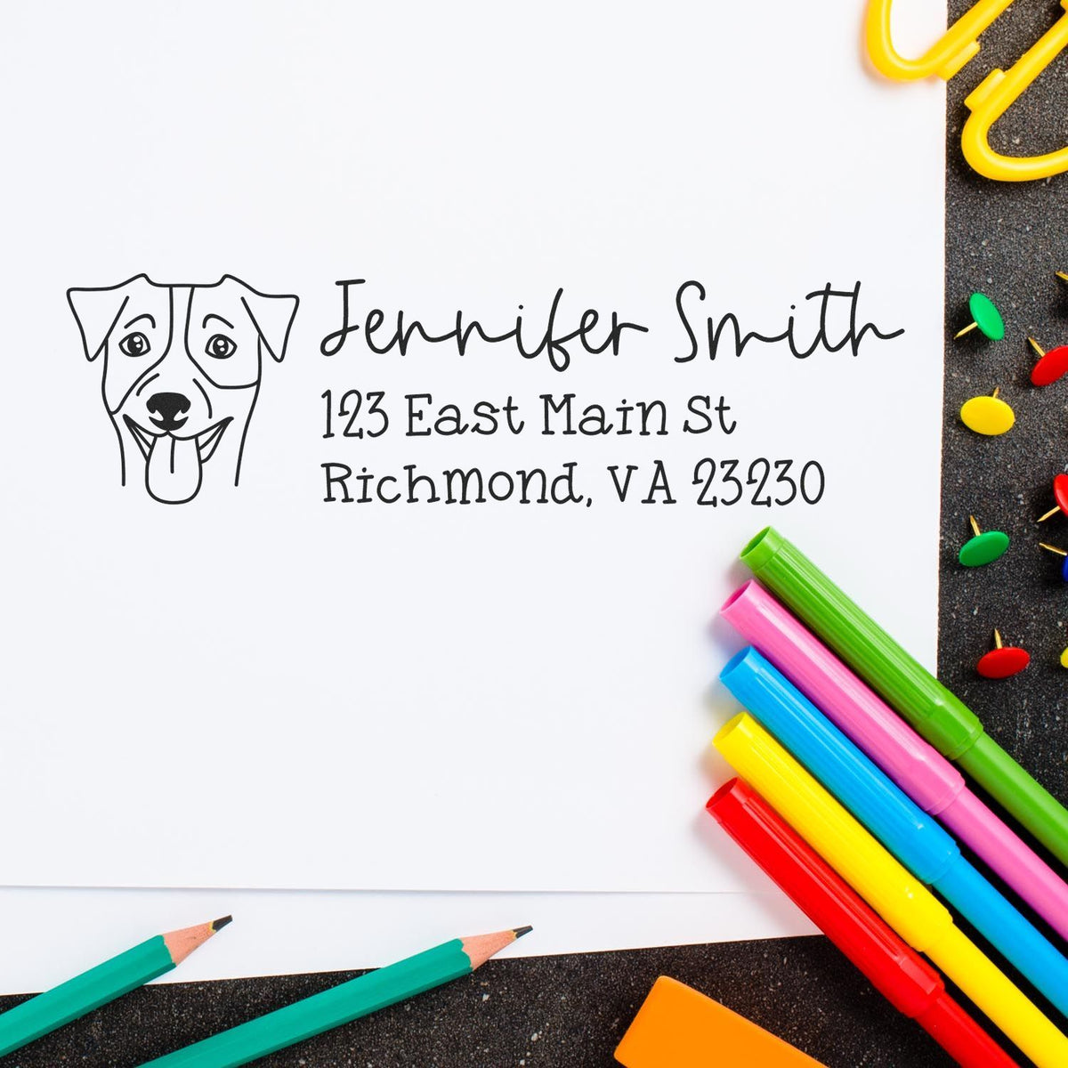 Custom dog address stamp and return address seal in black on white paper, surrounded by colorful markers.