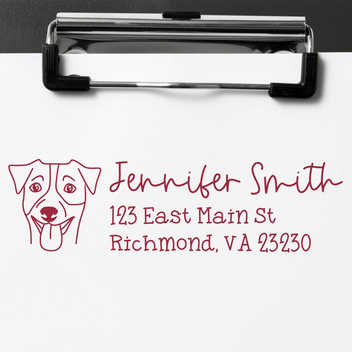 Burgundy custom dog return-address stamp with name and Richmond, VA address on white paper, clipped to a chrome clipboard.
